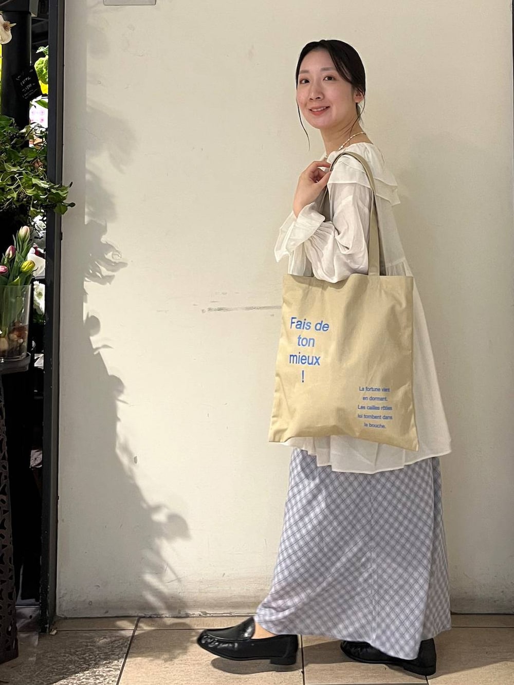 シルバー系のタンクトップ、ベージュ系のトートバッグ、ブラック系のローファーを着用したレディースの春コーディネートの3枚目の写真