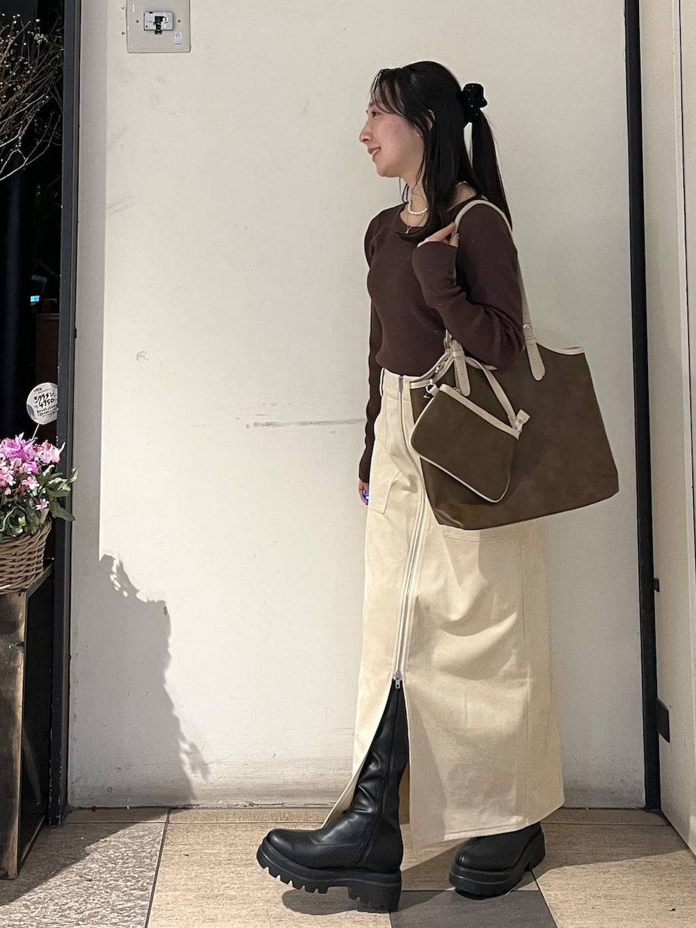 ホワイト系のスカート、ブラック系のブーツ、ブラウン系のニット/セーターを着用したレディースの冬コーディネートの3枚目の写真