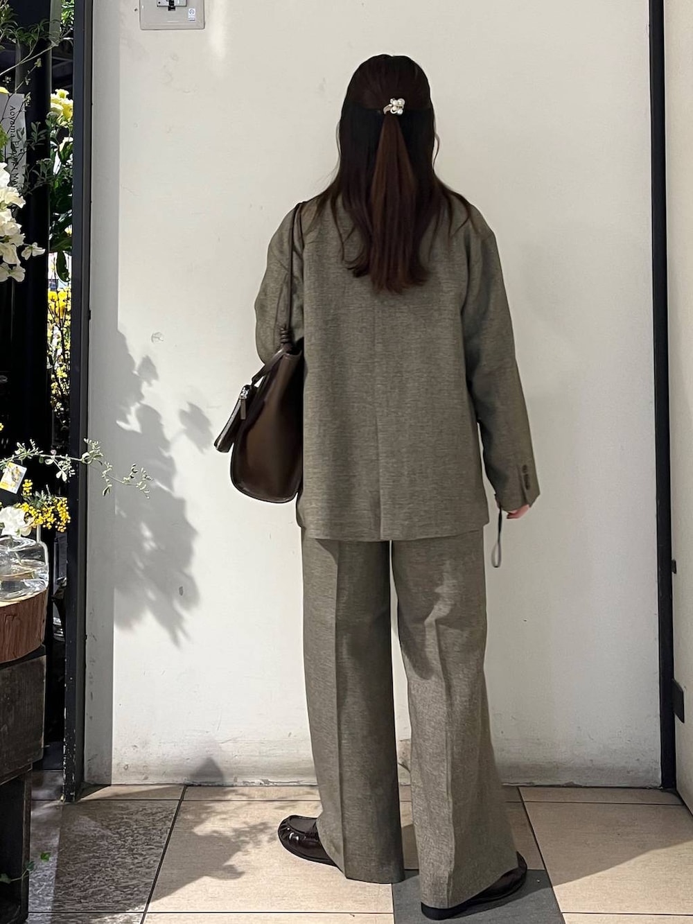 ブラウン系のテーラードジャケット、ブラウン系のデニムパンツ、ブラウン系のローファーを着用したレディースの春コーディネートの4枚目の写真