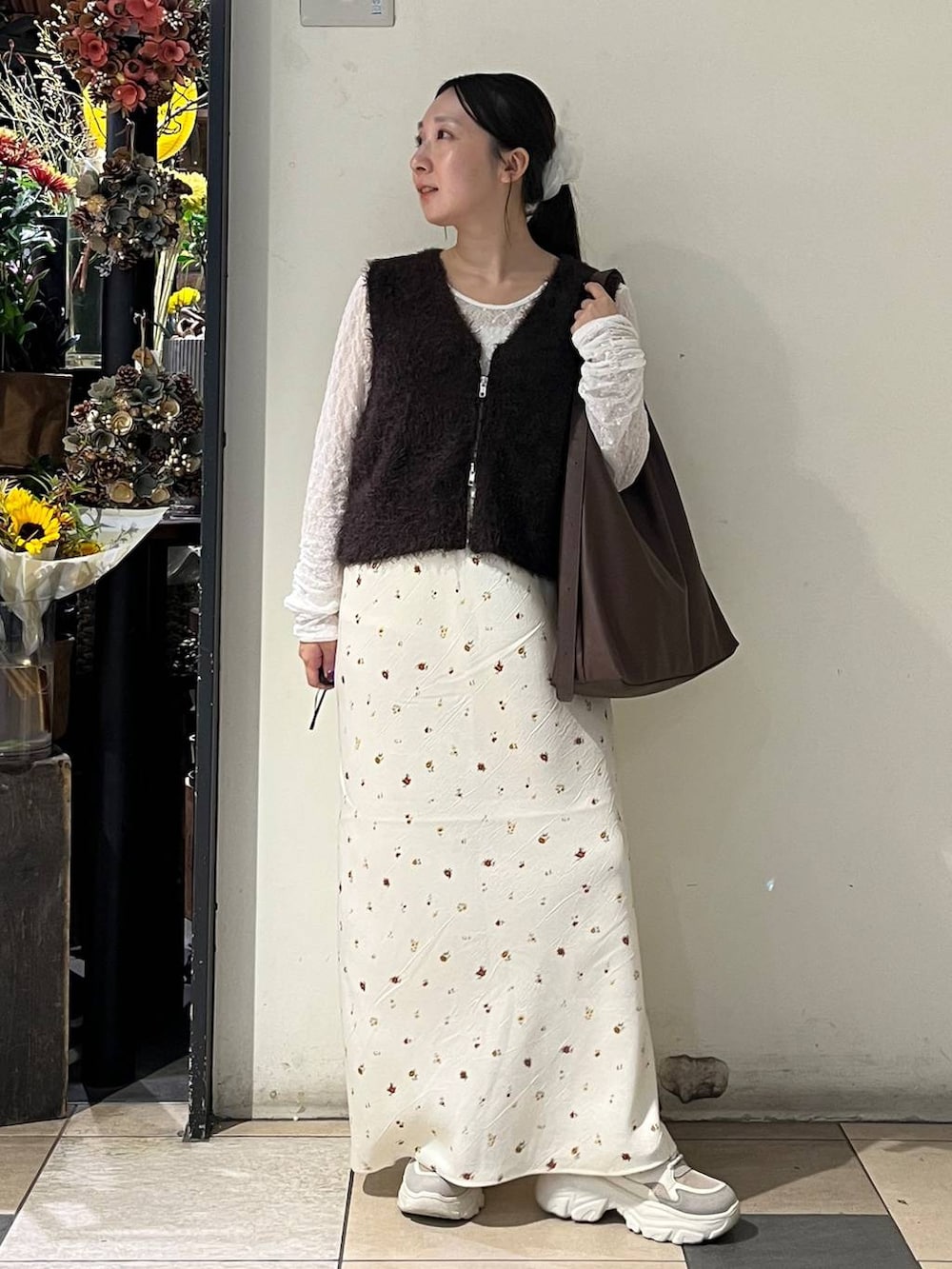 ホワイト系のTシャツ/カットソー、ブラウン系のショルダーバッグ、ベージュ系のスニーカーを着用したレディースの秋コーディネートの2枚目の写真