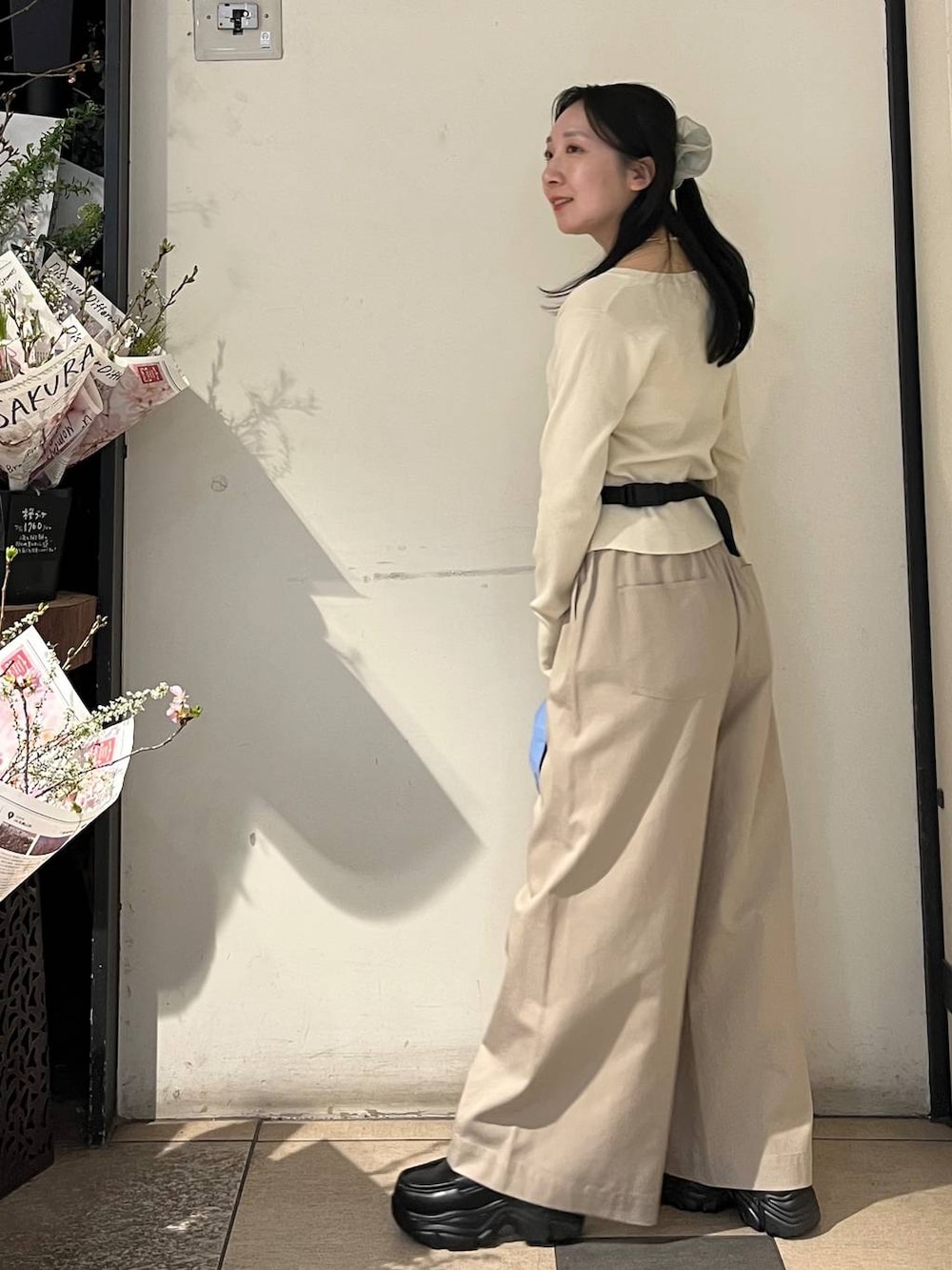 ベージュ系のデニムパンツ、ブラック系のローファー、ブラック系のボディバッグ/ウエストポーチを着用したレディースの春コーディネートの3枚目の写真