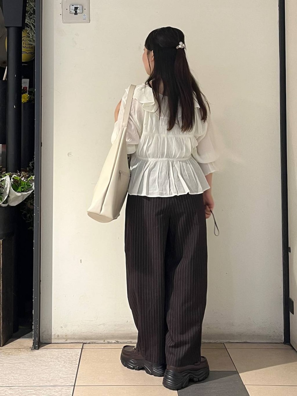 ホワイト系のショルダーバッグ、シルバー系のタンクトップ、ブラウン系のその他パンツを着用したレディースの夏コーディネートの4枚目の写真