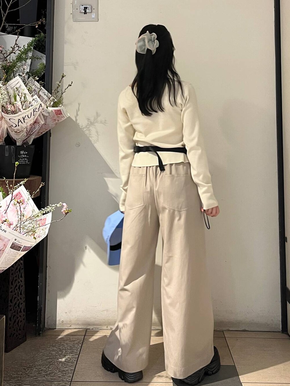 ベージュ系のデニムパンツ、ブラック系のローファー、ブラック系のボディバッグ/ウエストポーチを着用したレディースの春コーディネートの4枚目の写真