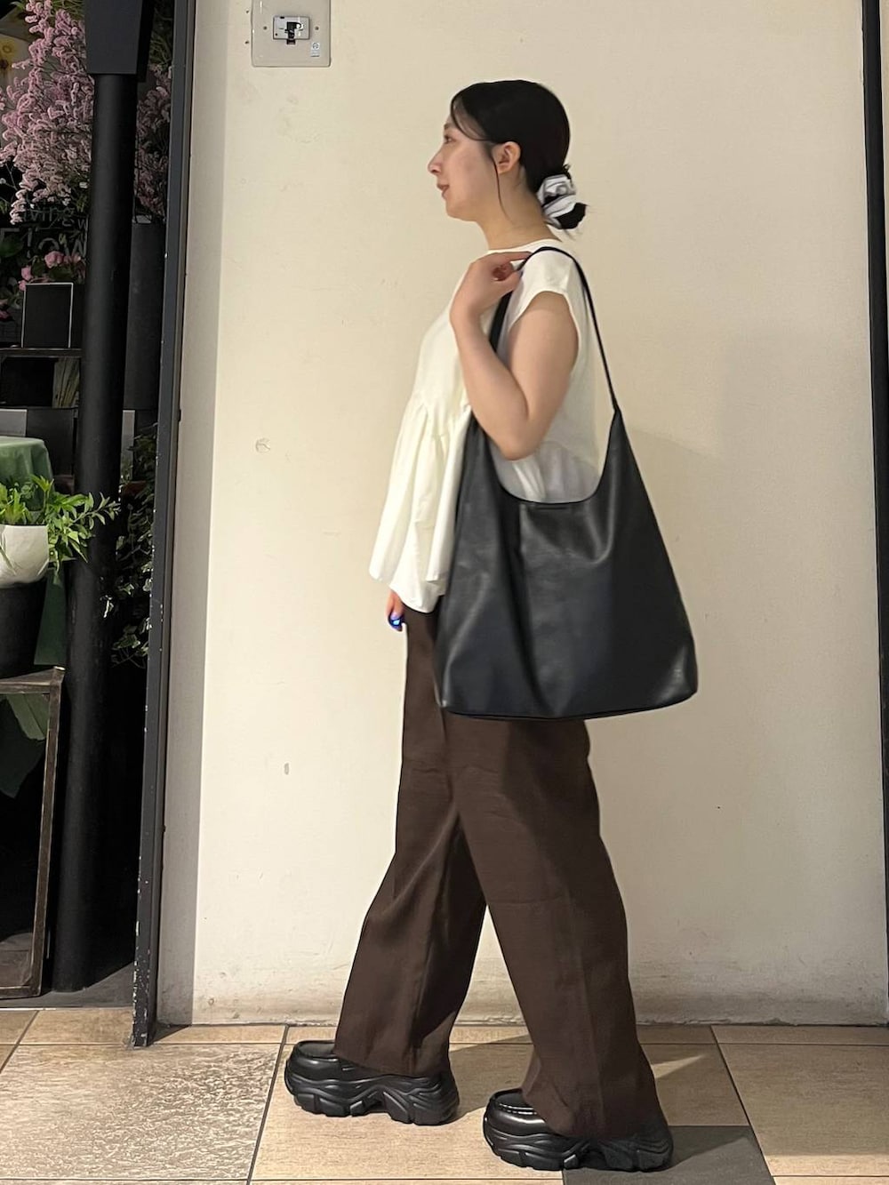ホワイト系のTシャツ/カットソー、ブラック系のショルダーバッグ、シルバー系のタンクトップを着用したレディースの夏コーディネートの3枚目の写真