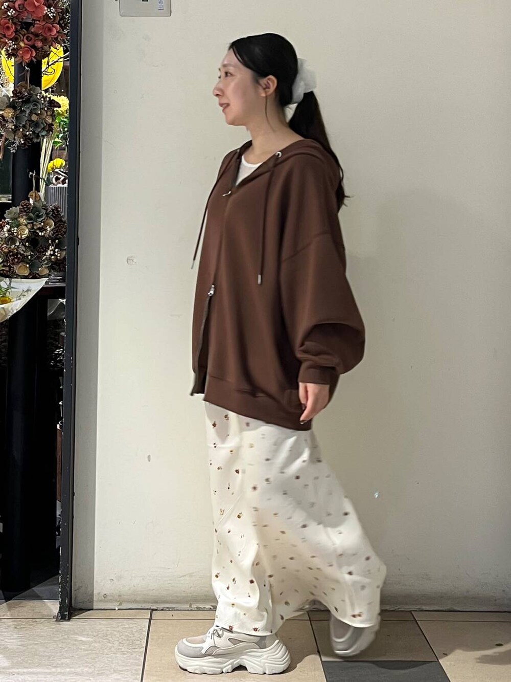 ホワイト系のTシャツ/カットソー、ホワイト系のスカート、シルバー系のタンクトップを着用したレディースの秋コーディネートの3枚目の写真
