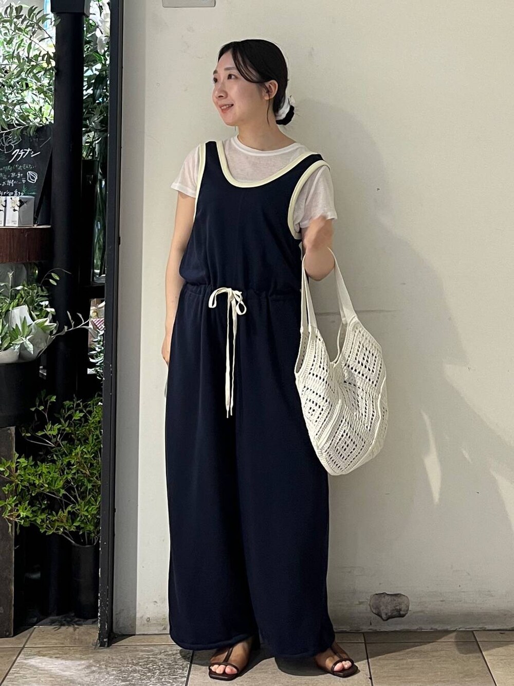シルバー系のタンクトップ、ホワイト系のTシャツ/カットソー、ブラウン系のサンダルを着用したレディースの夏コーディネートの2枚目の写真