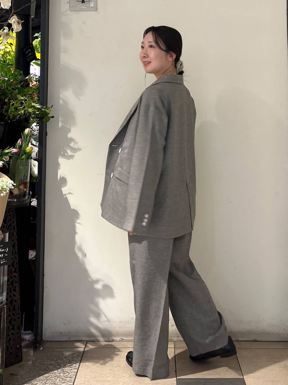 シルバー系のタンクトップ、グレー系のテーラードジャケット、グレー系のデニムパンツを着用したレディースの春コーディネートの6枚目の写真