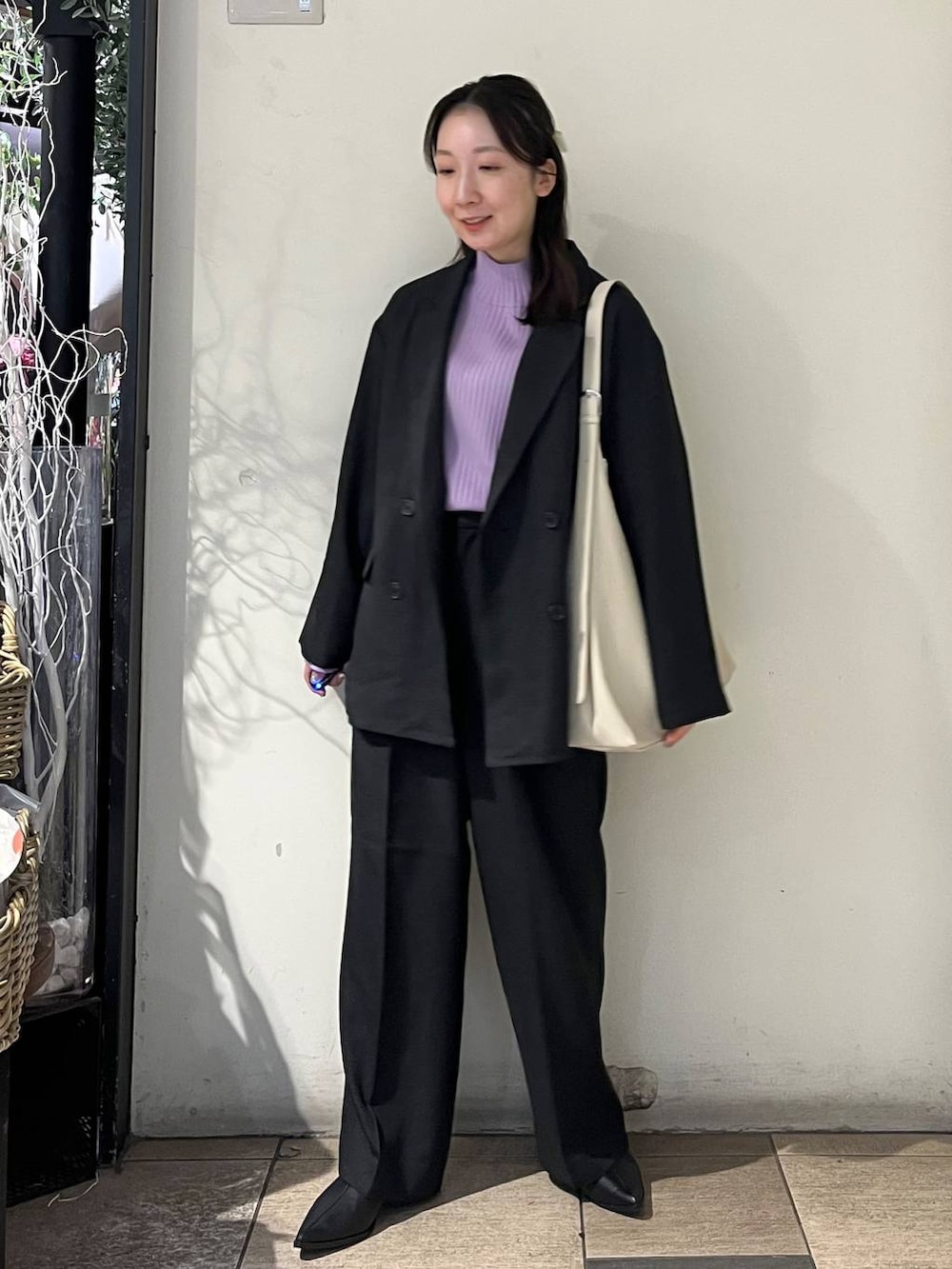 ホワイト系のショルダーバッグ、グレー系のテーラードジャケット、グレー系のその他パンツを着用したレディースの秋コーディネートの3枚目の写真