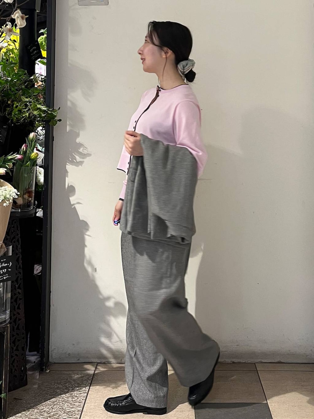 シルバー系のタンクトップ、グレー系のテーラードジャケット、グレー系のデニムパンツを着用したレディースの春コーディネートの4枚目の写真