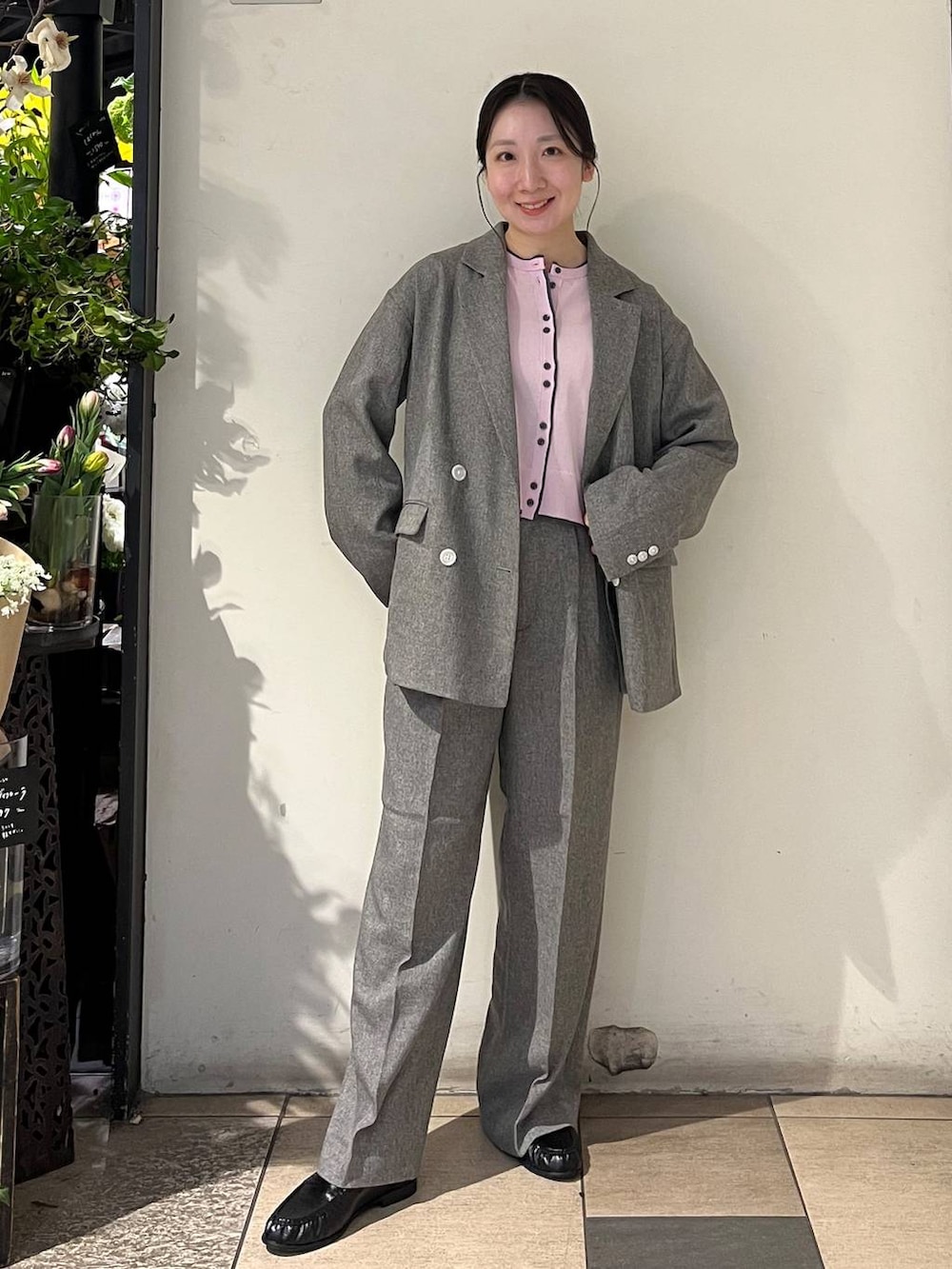 シルバー系のタンクトップ、グレー系のテーラードジャケット、グレー系のデニムパンツを着用したレディースの春コーディネートの2枚目の写真