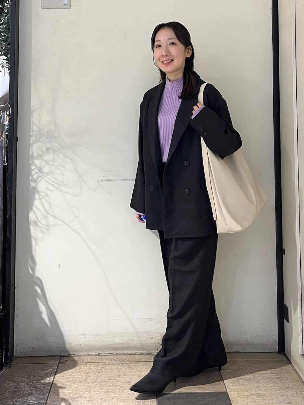 ホワイト系のショルダーバッグ、グレー系のテーラードジャケット、グレー系のその他パンツを着用したレディースの秋コーディネートの5枚目の写真