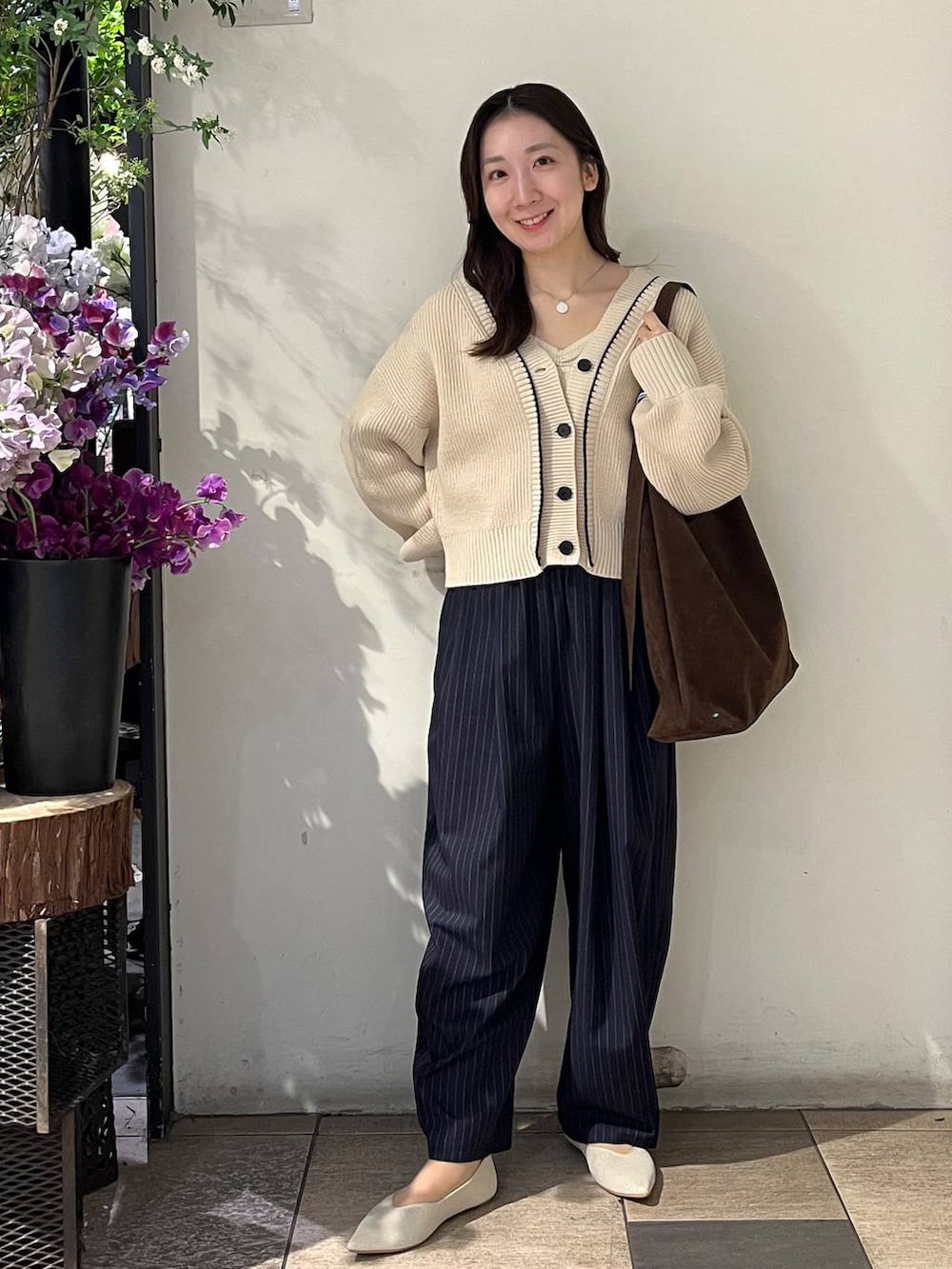 ブラウン系のショルダーバッグ、ブルー系のその他パンツ、ホワイト系のカーディガン/ボレロを着用したレディースの冬コーディネートの2枚目の写真