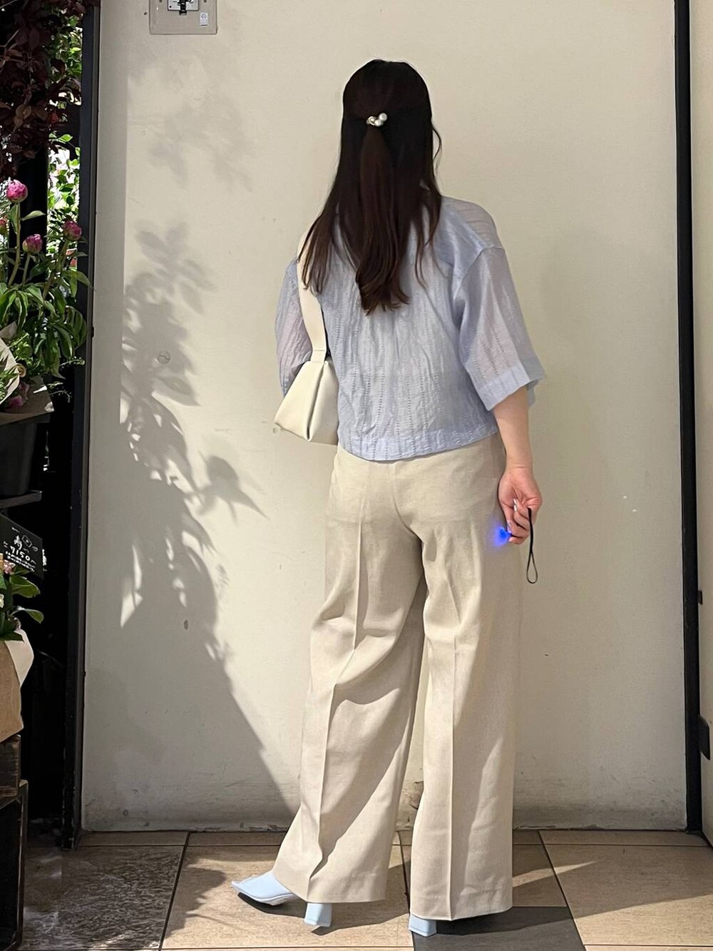 ベージュ系のその他パンツ、ホワイト系のタンクトップ、ホワイト系のショルダーバッグを着用したレディースの春コーディネートの4枚目の写真