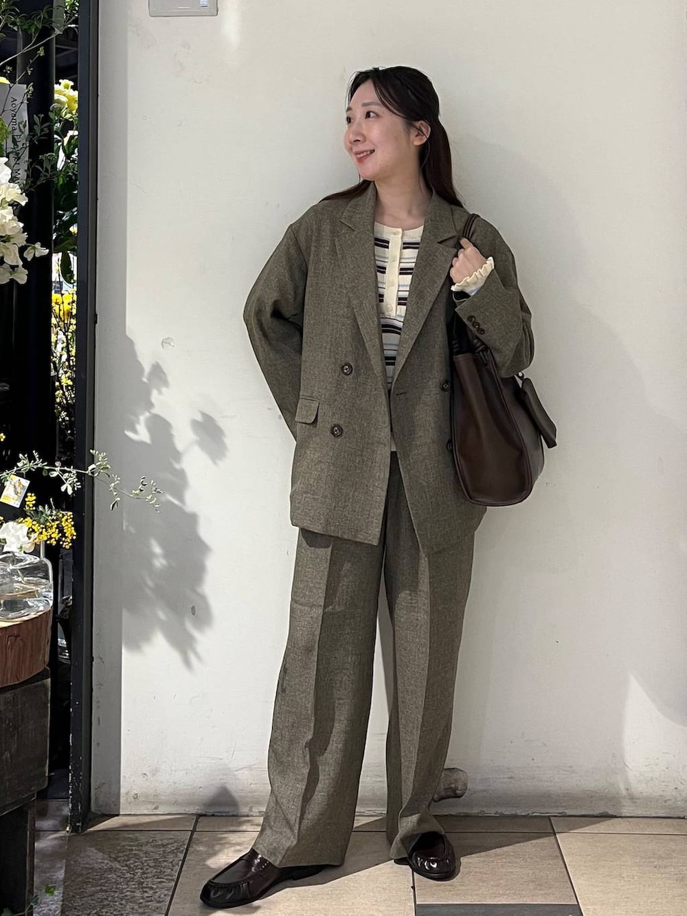 ブラウン系のテーラードジャケット、ブラウン系のデニムパンツ、ブラウン系のローファーを着用したレディースの春コーディネートの2枚目の写真