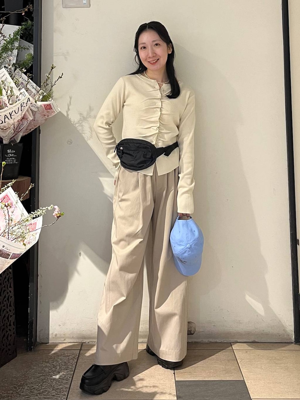 ベージュ系のデニムパンツ、ブラック系のローファー、ブラック系のボディバッグ/ウエストポーチを着用したレディースの春コーディネートの2枚目の写真