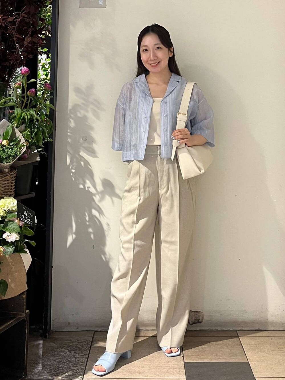 ベージュ系のその他パンツ、ホワイト系のタンクトップ、ホワイト系のショルダーバッグを着用したレディースの春コーディネートの2枚目の写真