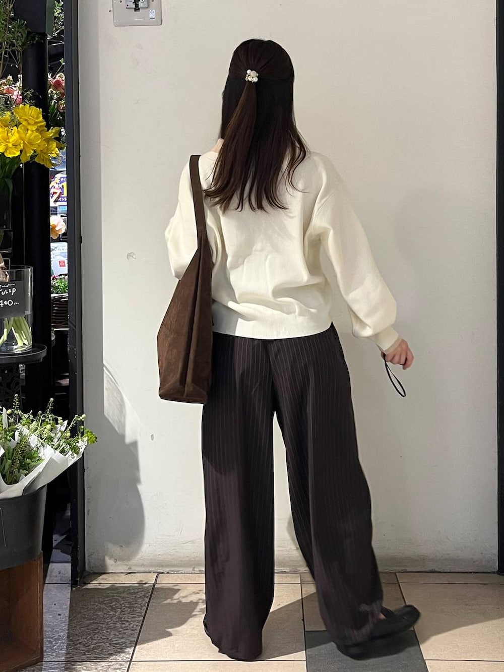 ブラウン系のショルダーバッグ、ブラウン系のその他パンツ、ホワイト系のニット/セーターを着用したレディースの冬コーディネートの4枚目の写真