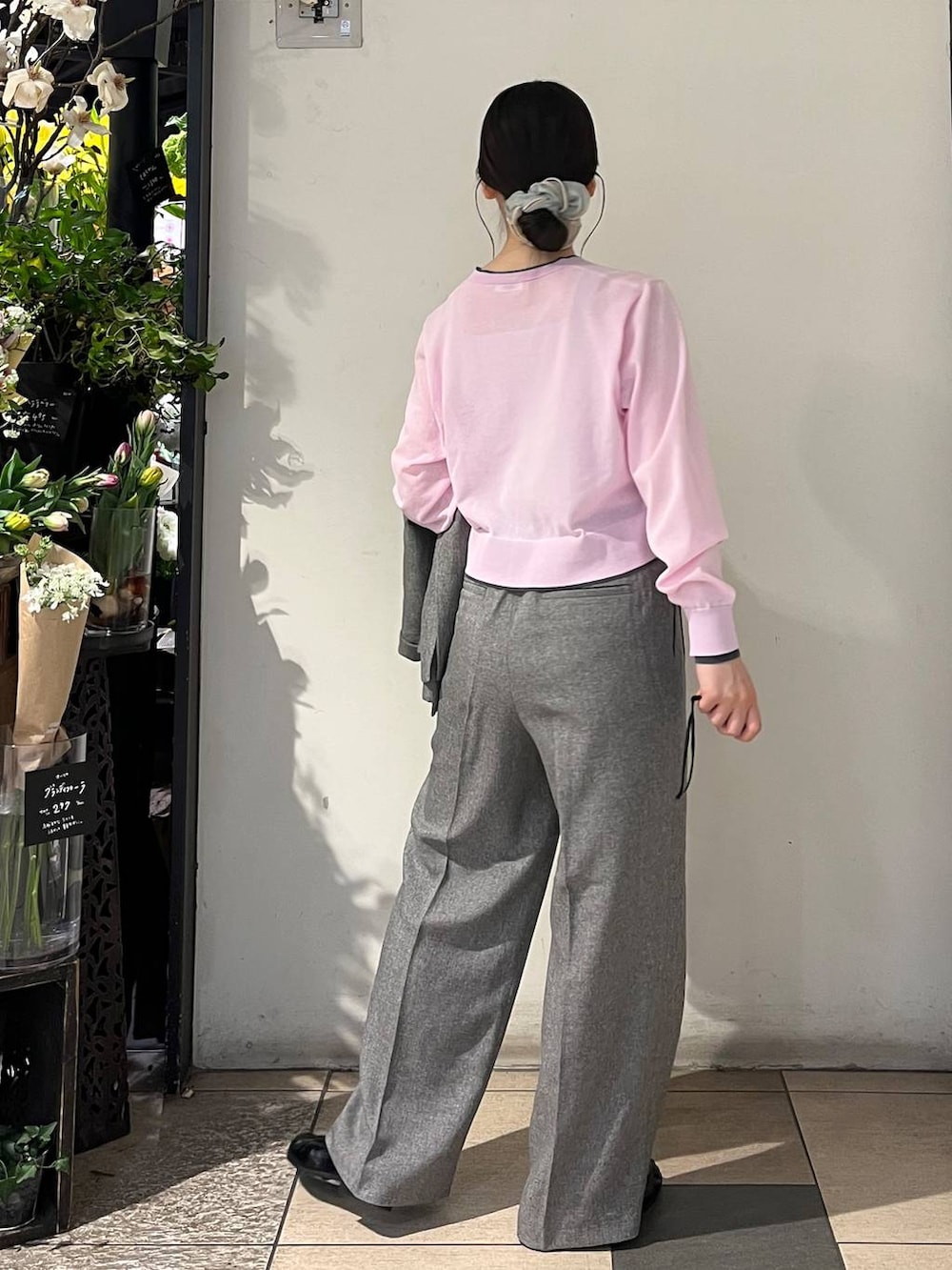 シルバー系のタンクトップ、グレー系のテーラードジャケット、グレー系のデニムパンツを着用したレディースの春コーディネートの5枚目の写真