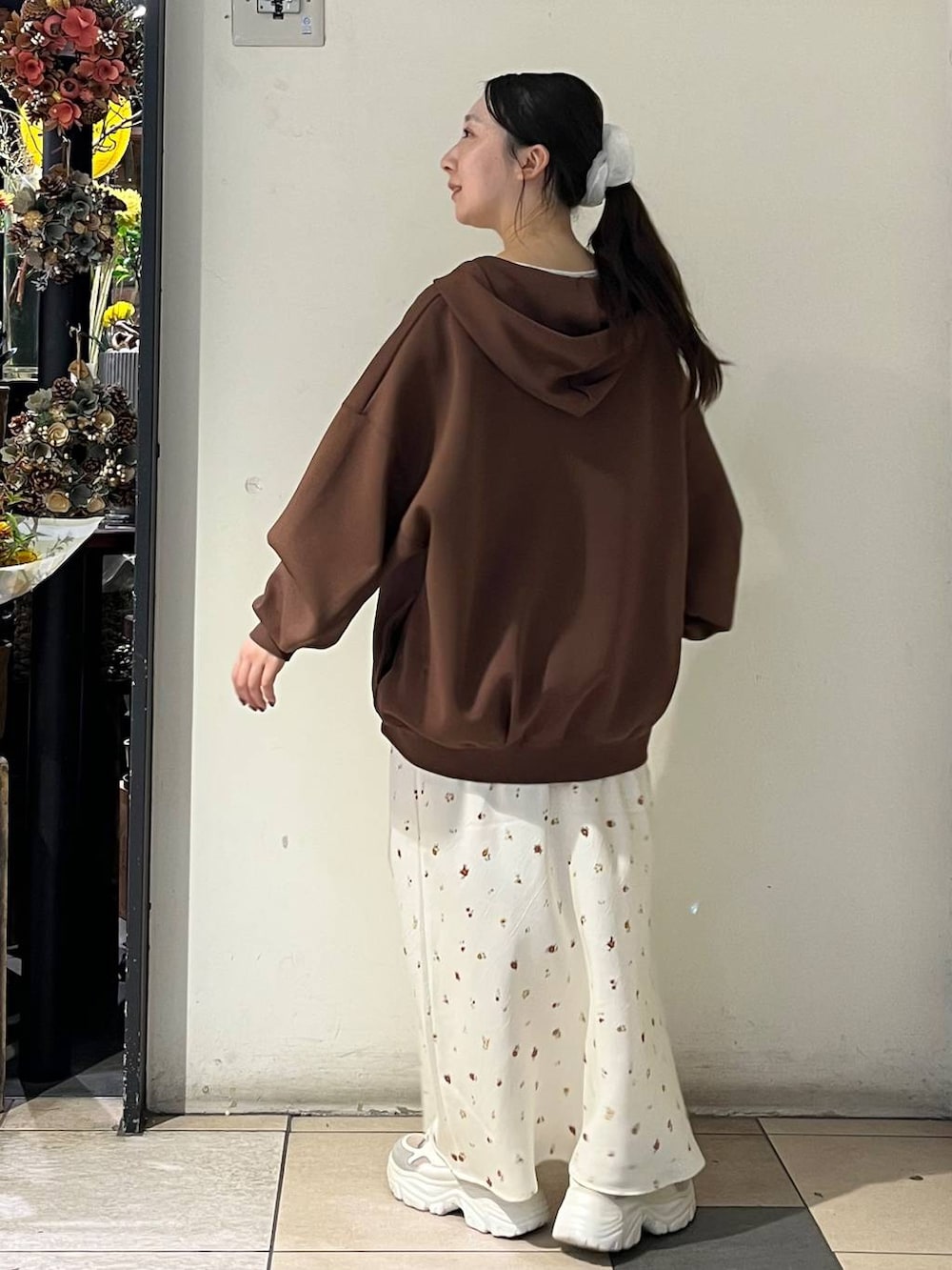 ホワイト系のTシャツ/カットソー、ホワイト系のスカート、シルバー系のタンクトップを着用したレディースの秋コーディネートの4枚目の写真