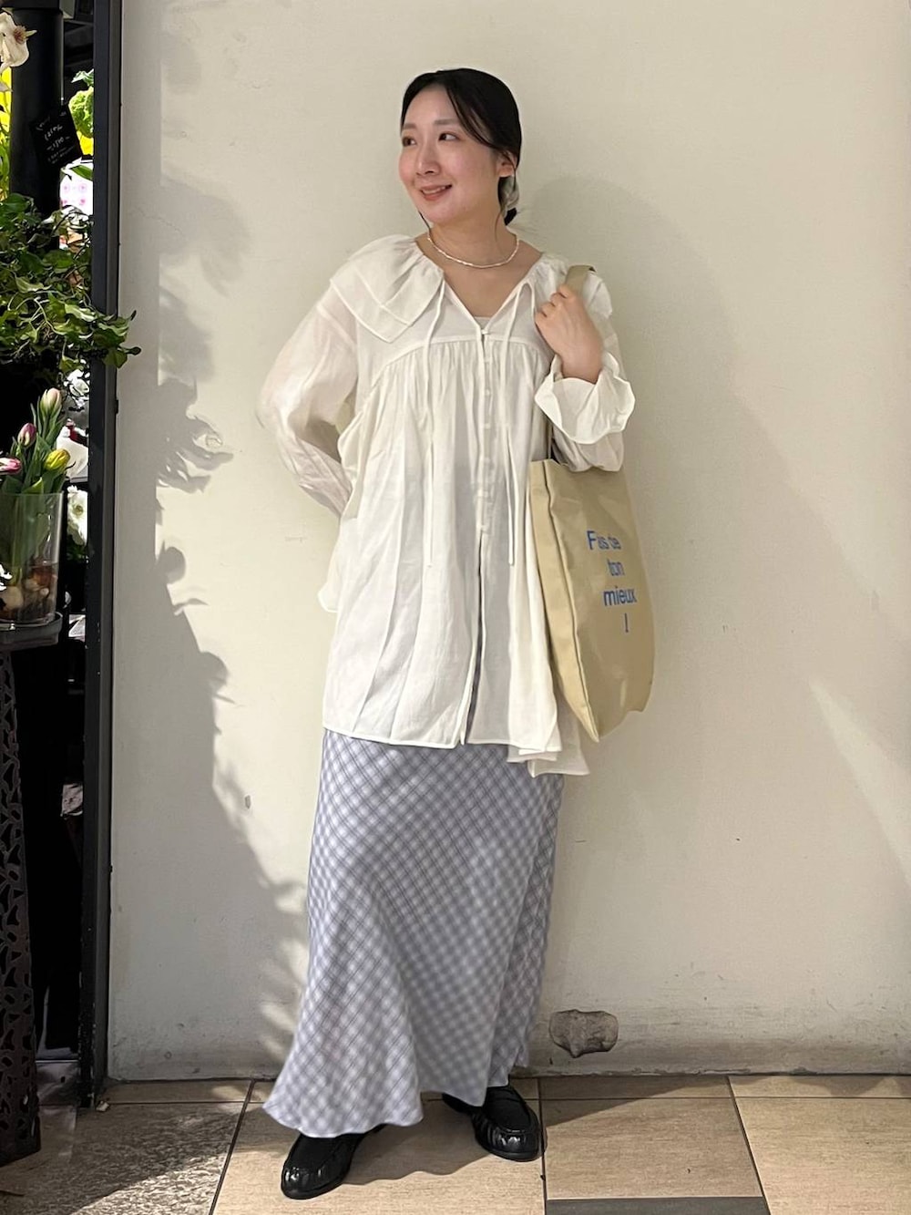 シルバー系のタンクトップ、ベージュ系のトートバッグ、ブラック系のローファーを着用したレディースの春コーディネートの2枚目の写真