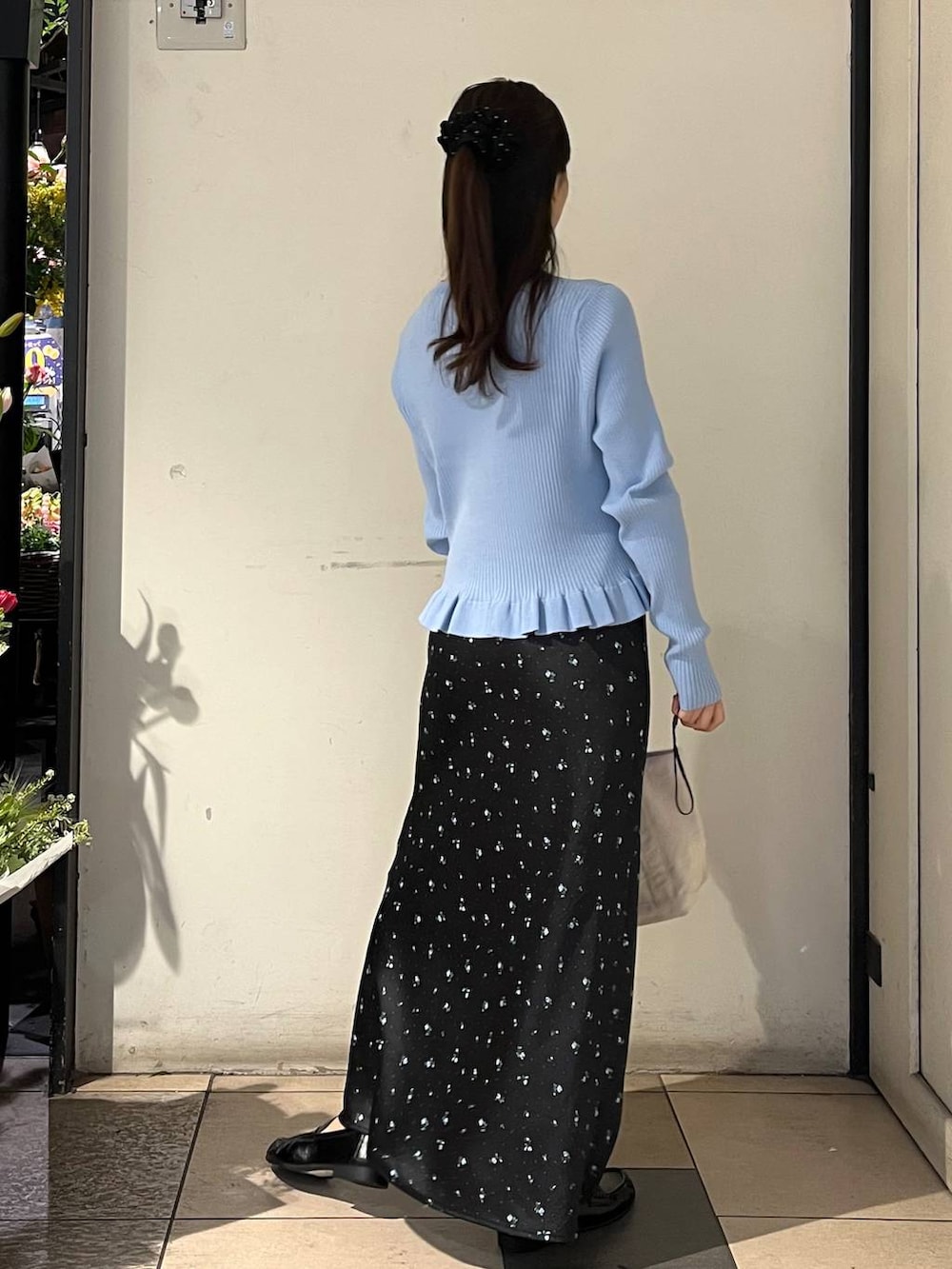 ブラック系のスカート、ホワイト系のショルダーバッグ、ブルー系のTシャツ/カットソーを着用したレディースの冬コーディネートの4枚目の写真