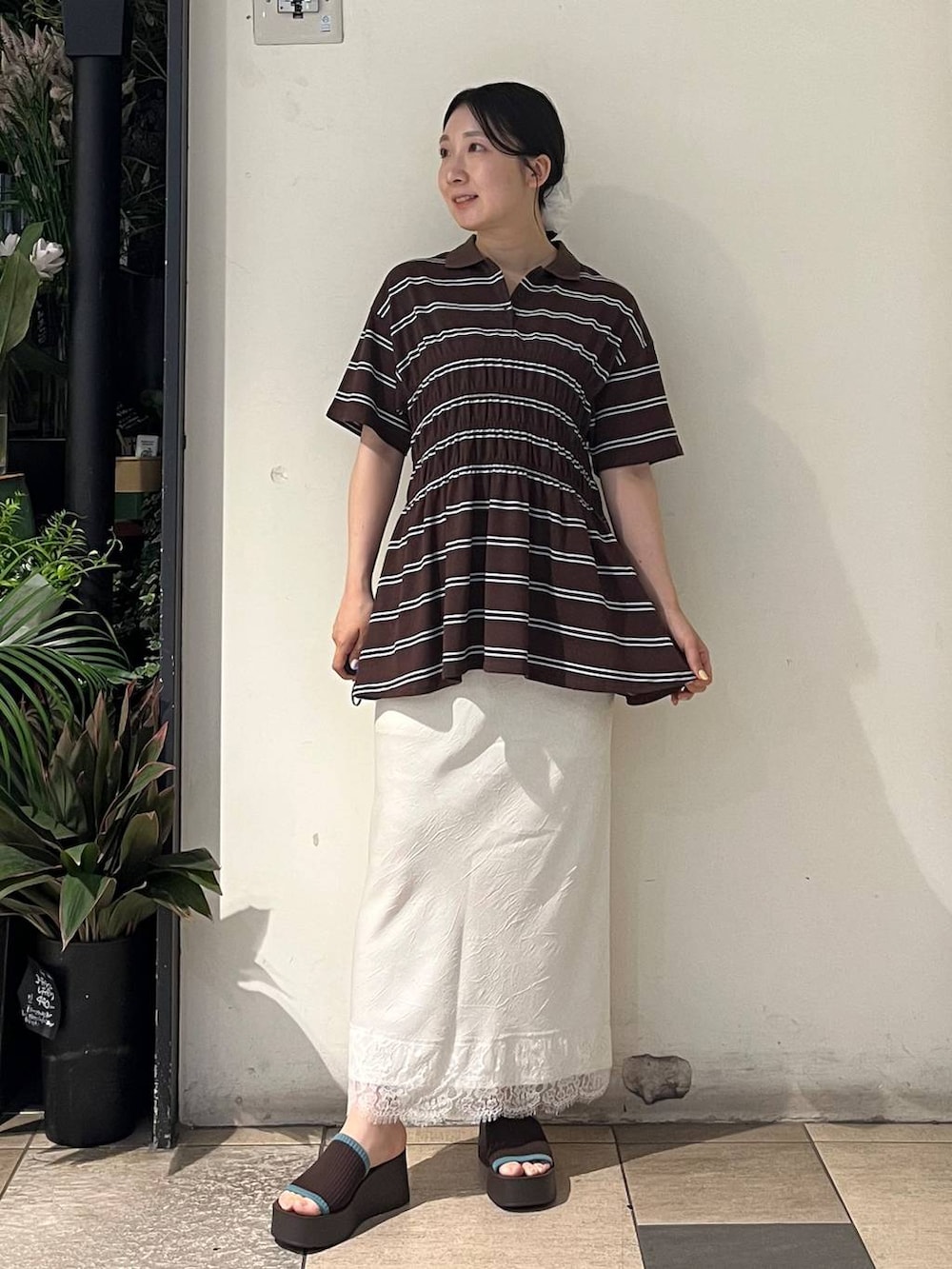 ブラウン系のサンダル、ホワイト系のスカート、ブラウン系のTシャツ/カットソーを着用したレディースの夏コーディネートの2枚目の写真