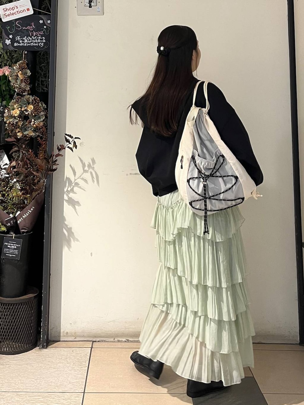 グリーン系のスカート、ブラック系のローファー、その他のTシャツ/カットソーを着用したレディースの秋コーディネートの4枚目の写真