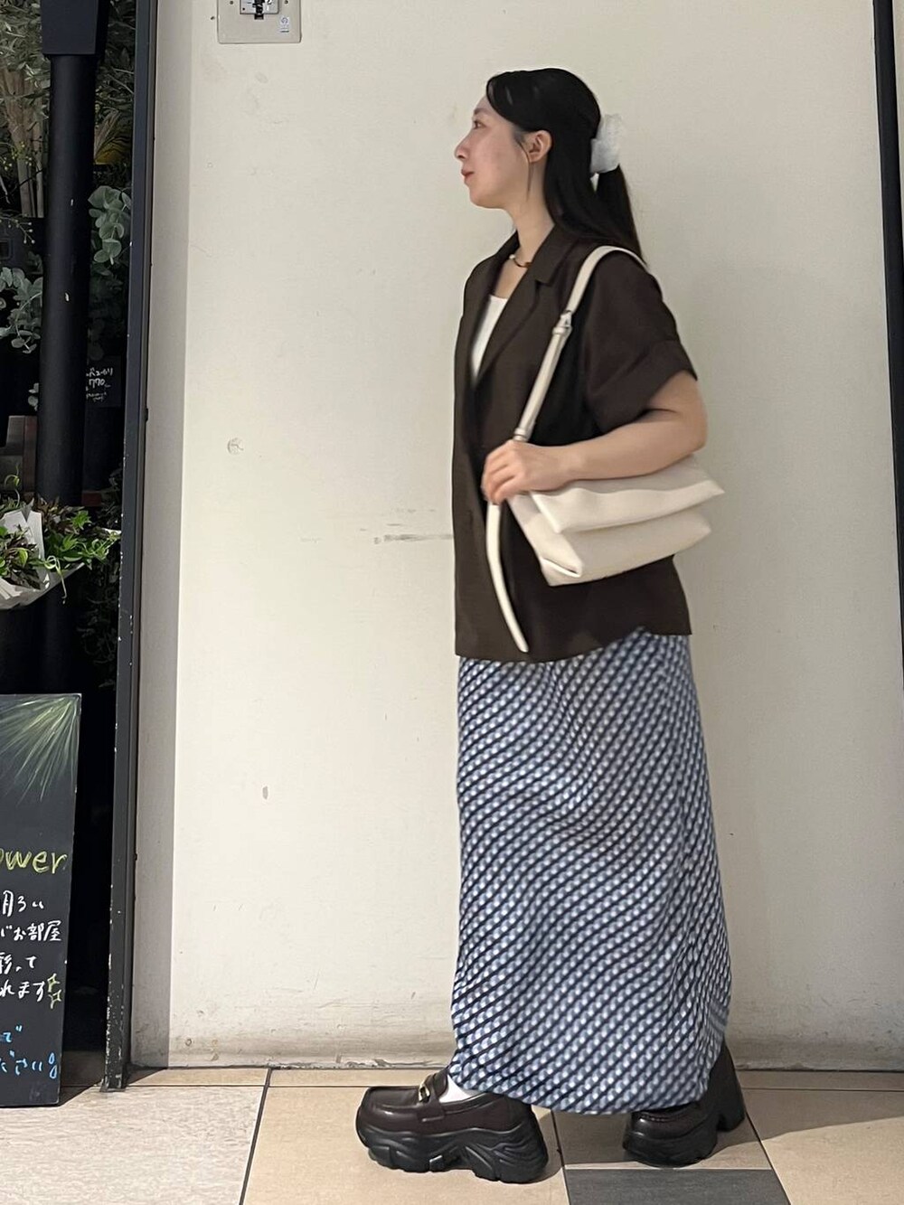 ホワイト系のショルダーバッグ、ブルー系のスカート、シルバー系のタンクトップを着用したレディースの夏コーディネートの3枚目の写真