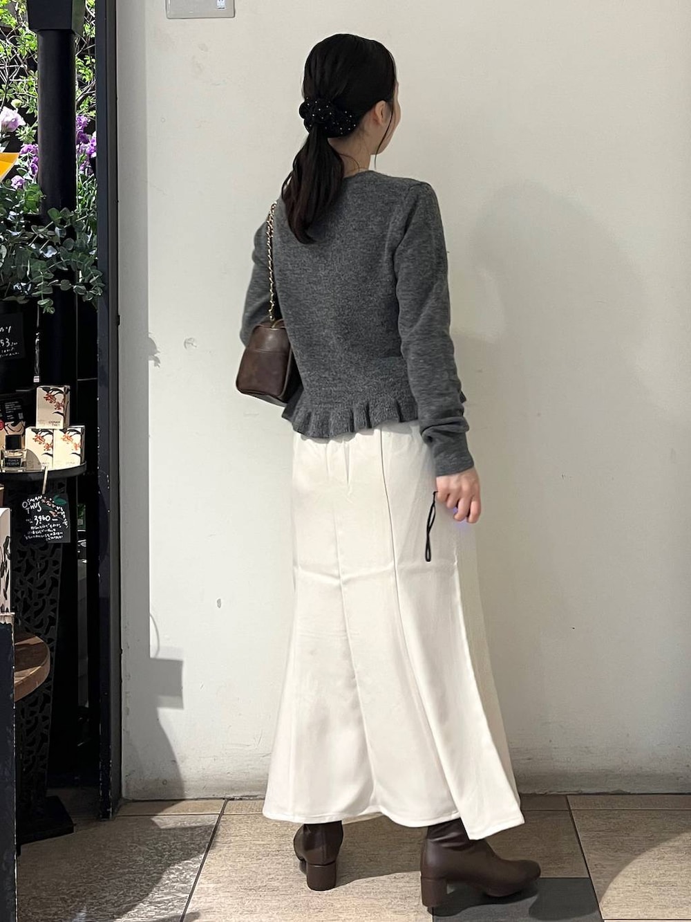 ホワイト系のスカート、ブラウン系のブーツ、グレー系のニット/セーターを着用したレディースの秋コーディネートの4枚目の写真