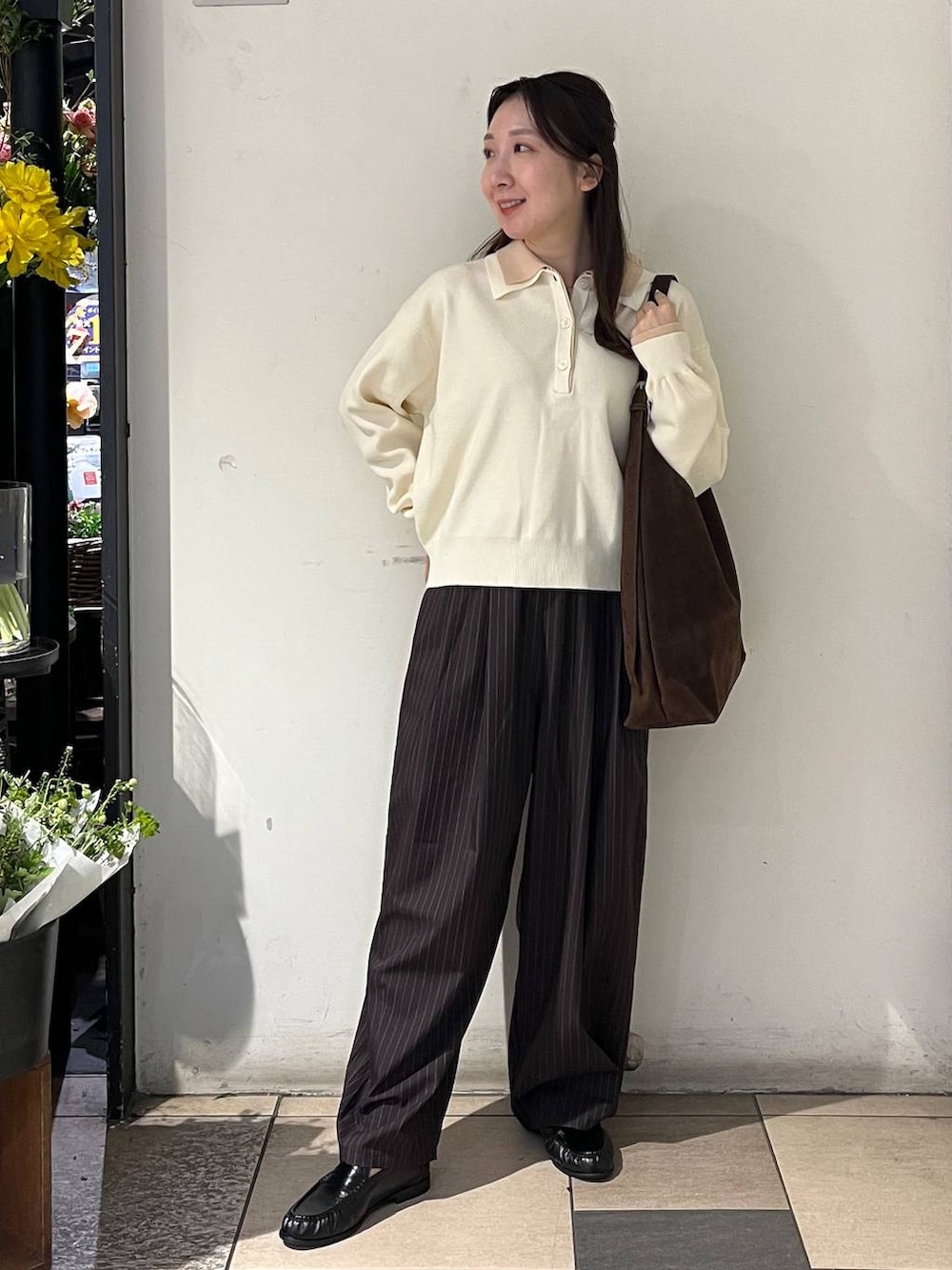 ブラウン系のショルダーバッグ、ブラウン系のその他パンツ、ホワイト系のニット/セーターを着用したレディースの冬コーディネートの2枚目の写真