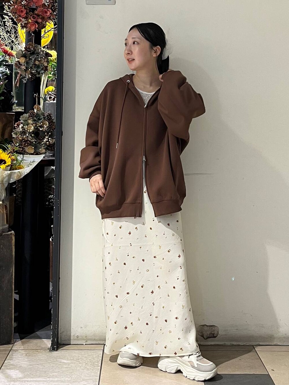 ホワイト系のTシャツ/カットソー、ホワイト系のスカート、シルバー系のタンクトップを着用したレディースの秋コーディネートの2枚目の写真