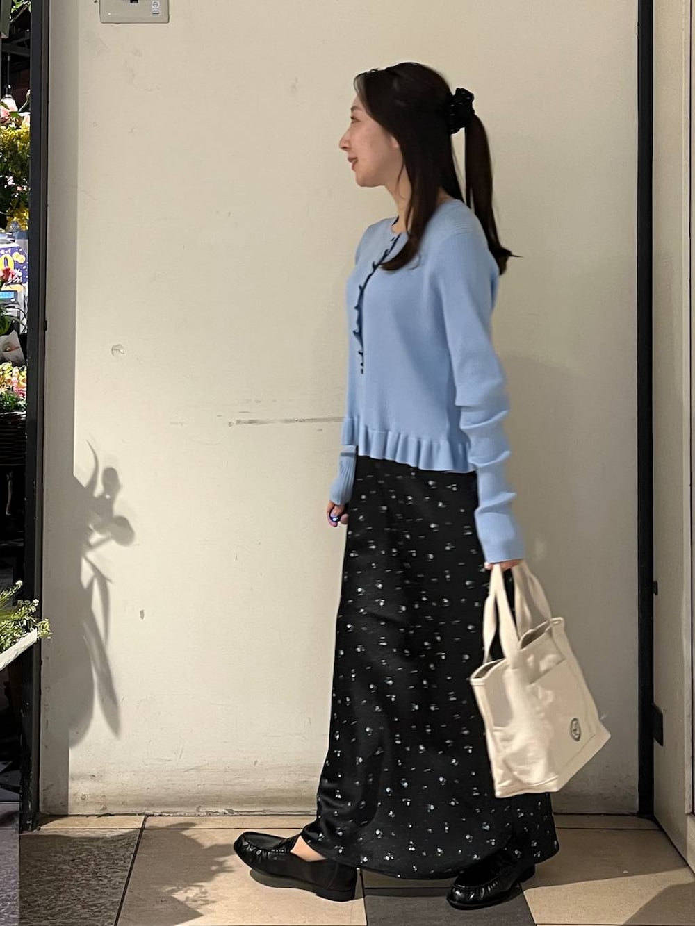 ブラック系のスカート、ホワイト系のショルダーバッグ、ブルー系のTシャツ/カットソーを着用したレディースの冬コーディネートの3枚目の写真