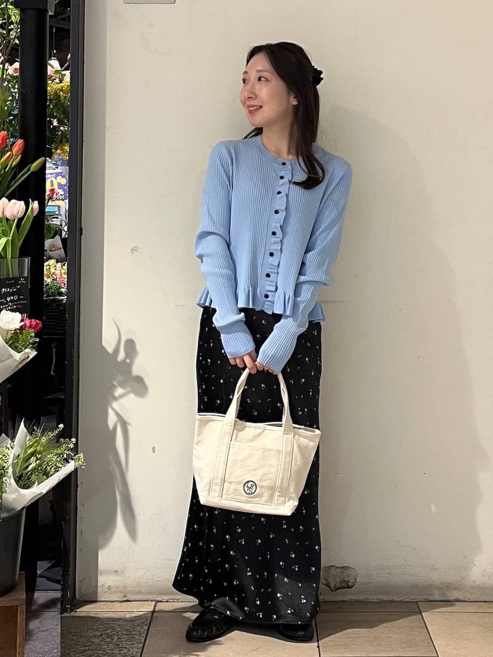 ブラック系のスカート、ホワイト系のショルダーバッグ、ブルー系のTシャツ/カットソーを着用したレディースの冬コーディネートの2枚目の写真