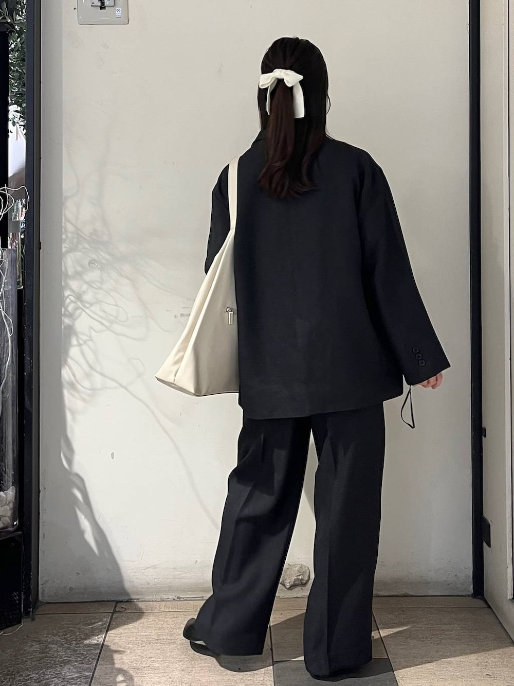 ホワイト系のショルダーバッグ、グレー系のテーラードジャケット、グレー系のその他パンツを着用したレディースの秋コーディネートの4枚目の写真