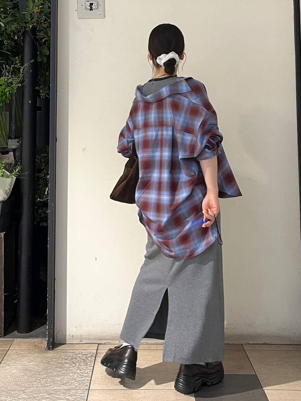 グレー系のワンピース、ブラウン系のローファー、ブラウン系のショルダーバッグを着用したレディースの夏コーディネートの4枚目の写真