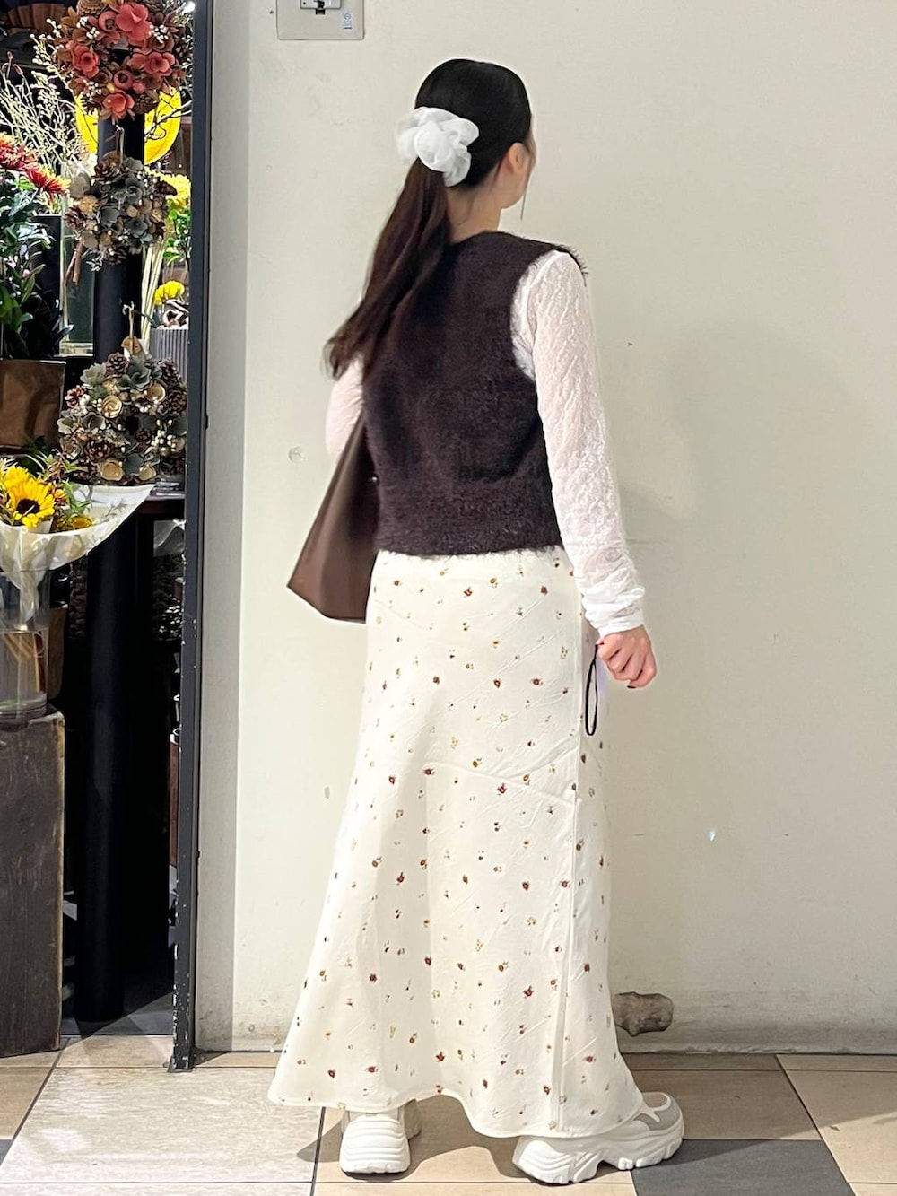 ホワイト系のTシャツ/カットソー、ブラウン系のショルダーバッグ、ベージュ系のスニーカーを着用したレディースの秋コーディネートの4枚目の写真
