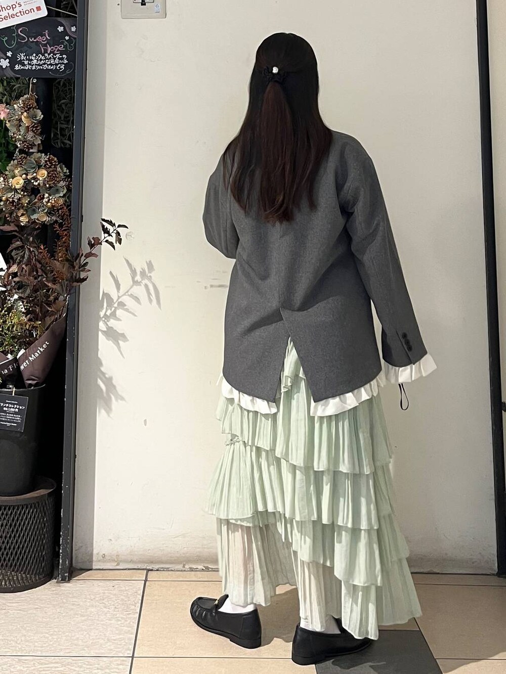 ホワイト系のTシャツ/カットソー、グレー系のテーラードジャケット、グリーン系のスカートを着用したレディースの秋コーディネートの3枚目の写真