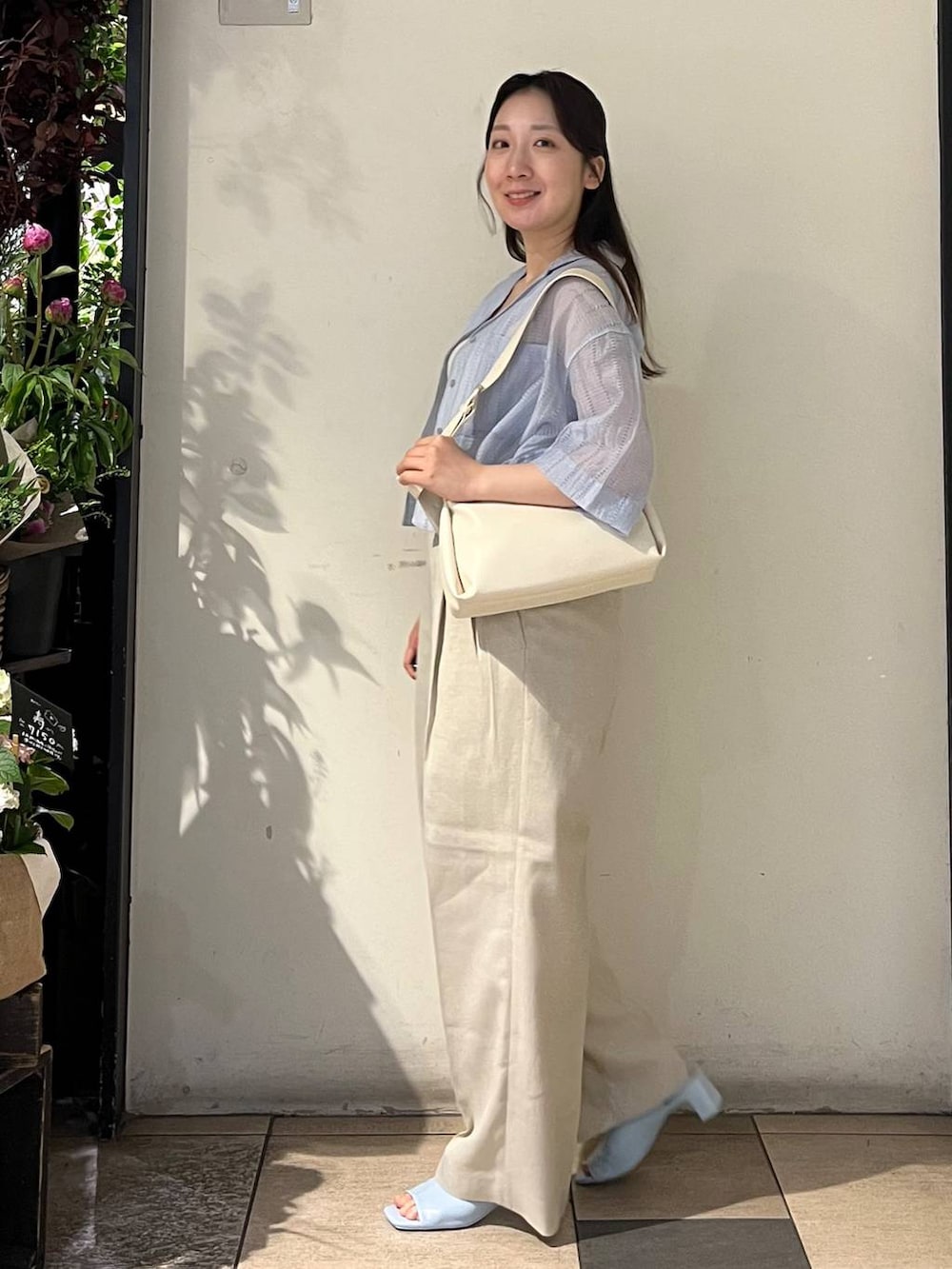 ベージュ系のその他パンツ、ホワイト系のタンクトップ、ホワイト系のショルダーバッグを着用したレディースの春コーディネートの3枚目の写真