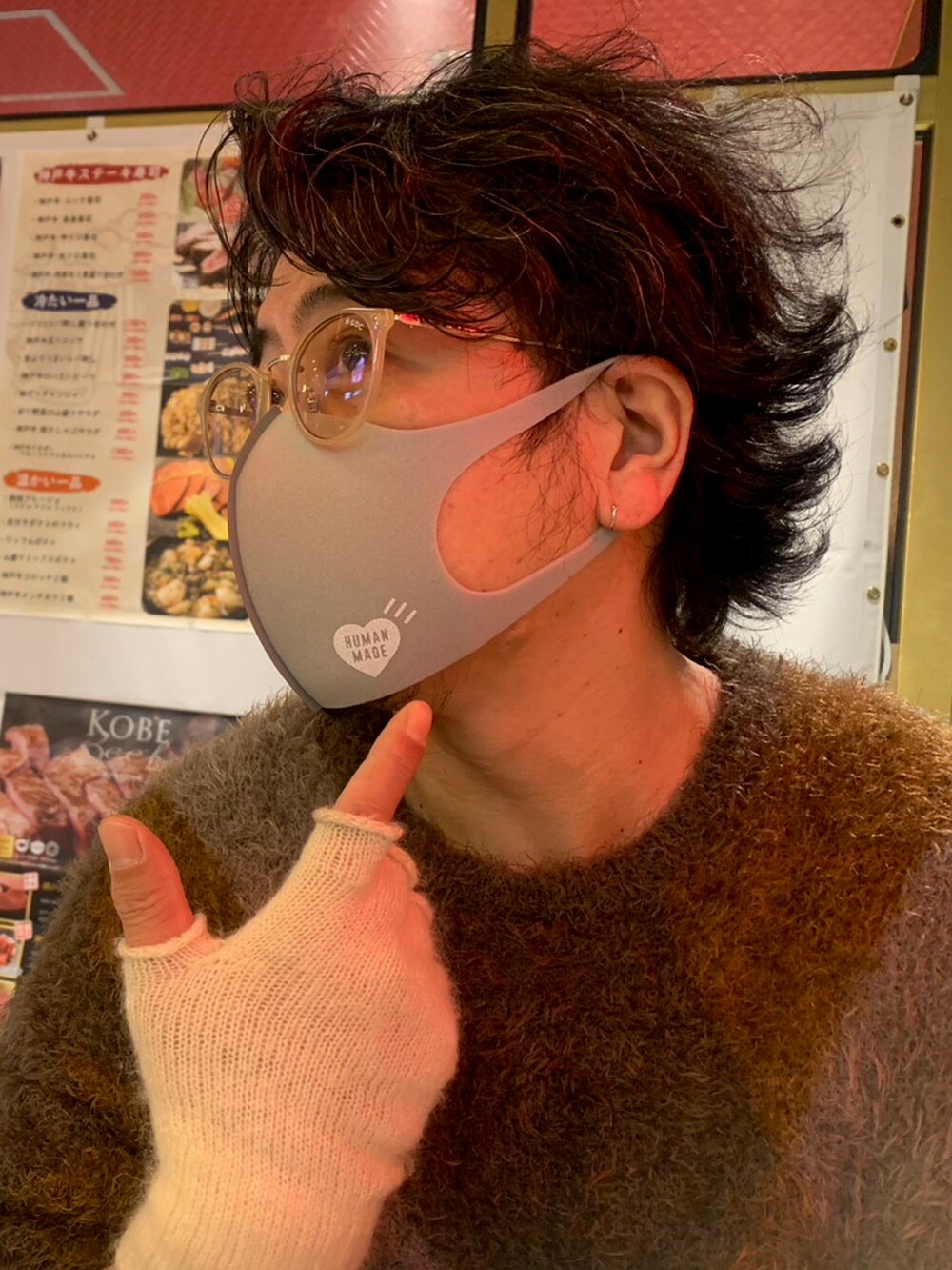 ブラウン系のニット/セーター、ブラウン系のチノパンツ、ホワイト系のアームカバーを着用したメンズの春コーディネートの2枚目の写真