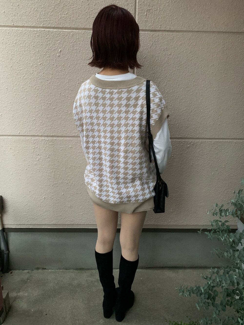 ホワイト系のトップス、ベージュ系のベスト、ベージュ系のデニムパンツを着用したレディースの秋コーディネートの2枚目の写真