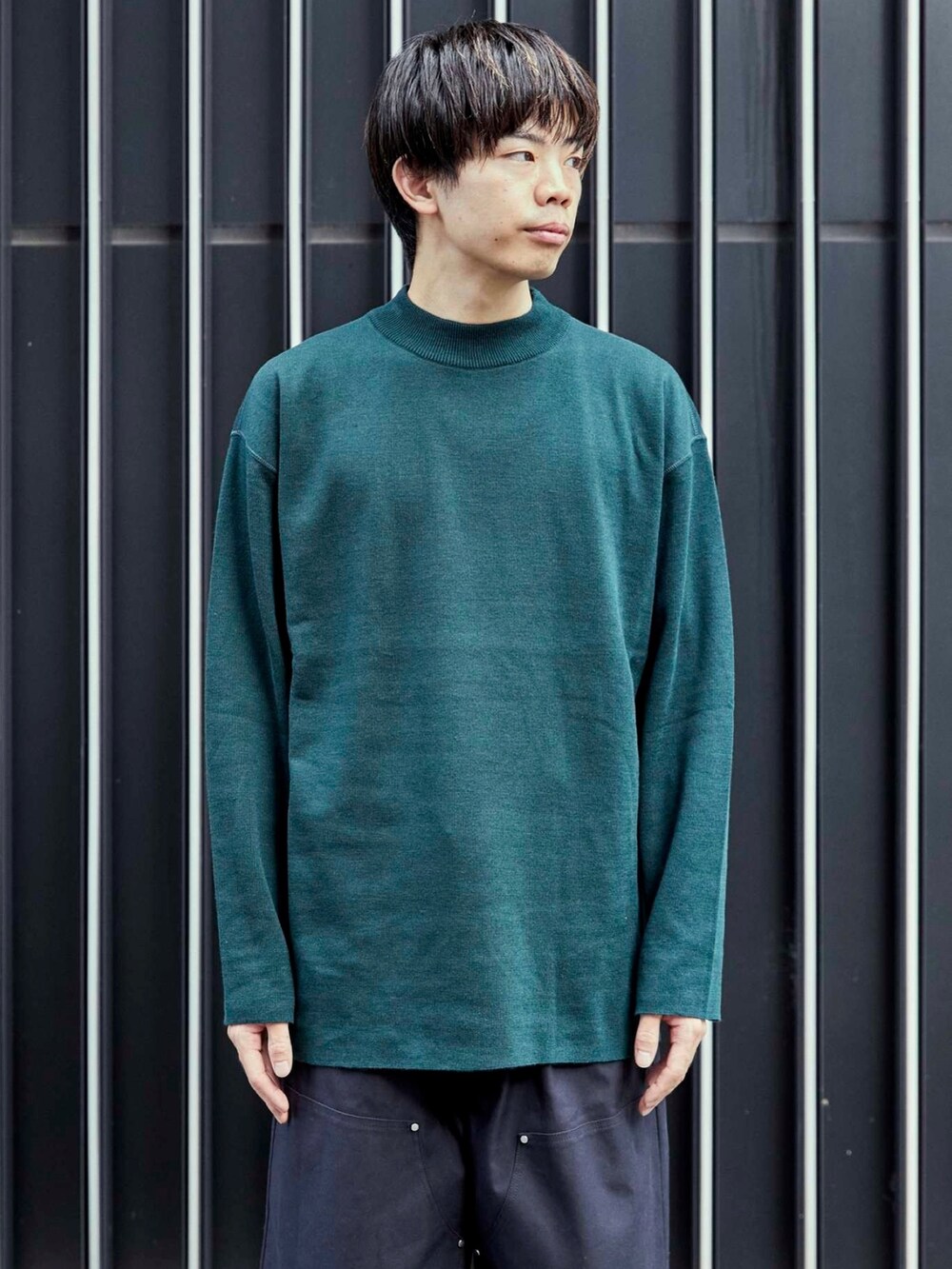 グリーン系のニット/セーターを着用したメンズの秋コーディネートの5枚目の写真