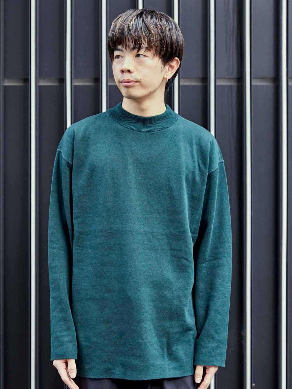 グリーン系のニット/セーターを着用したメンズの秋コーディネートの4枚目の写真
