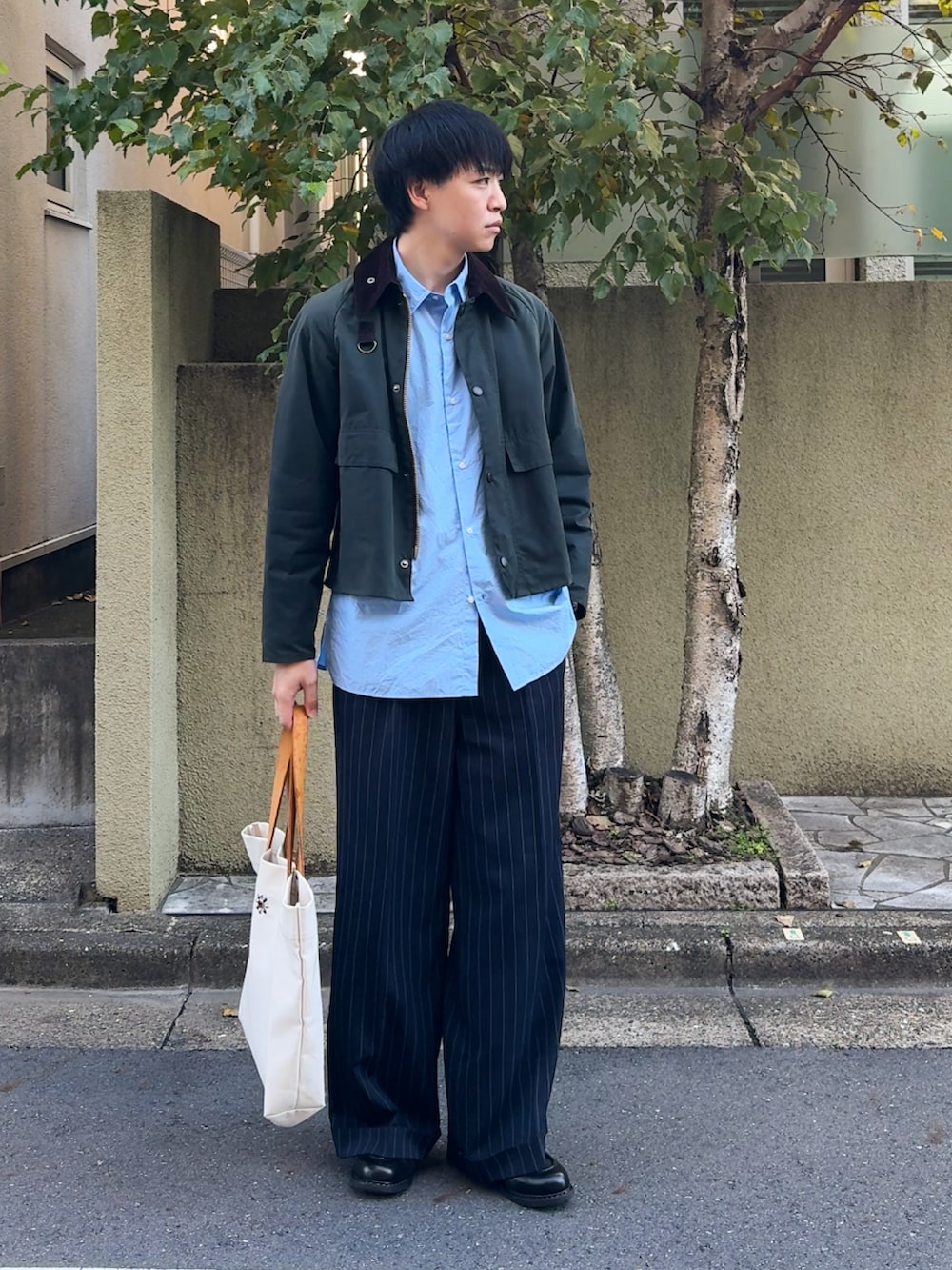 グリーン系のブルゾン、ブルー系のシャツ/ブラウス、ブラック系のスラックスを着用したメンズの秋コーディネートの2枚目の写真