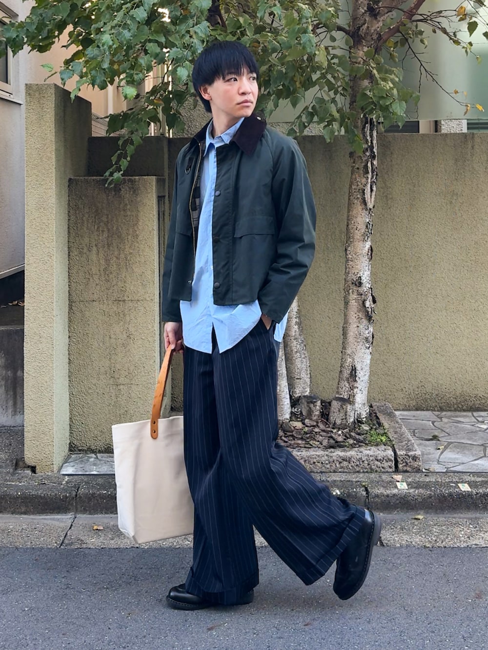 グリーン系のブルゾン、ブルー系のシャツ/ブラウス、ブラック系のスラックスを着用したメンズの秋コーディネートの5枚目の写真