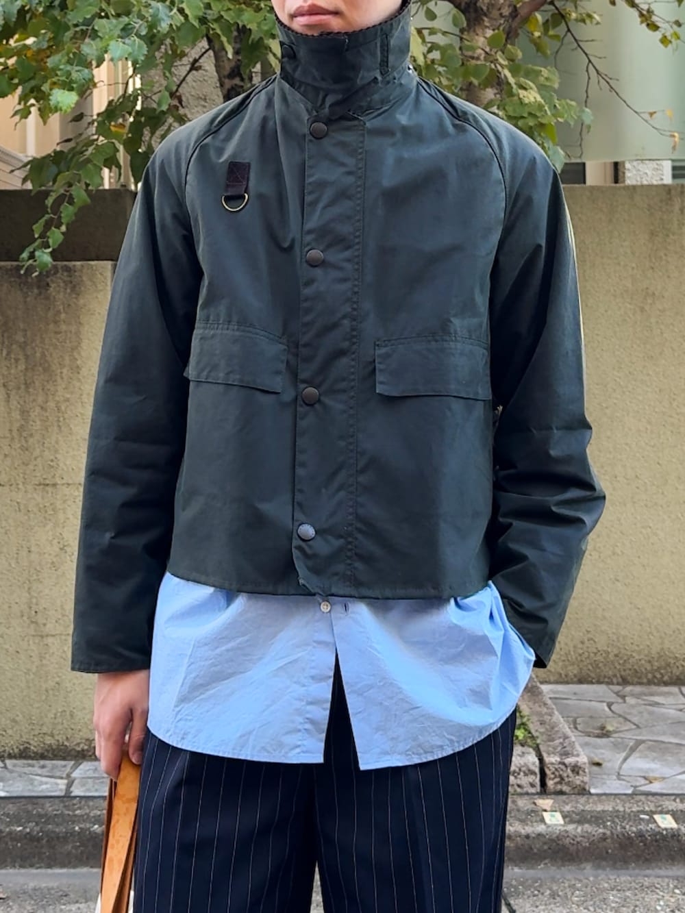 グリーン系のブルゾン、ブルー系のシャツ/ブラウス、ブラック系のスラックスを着用したメンズの秋コーディネートの3枚目の写真