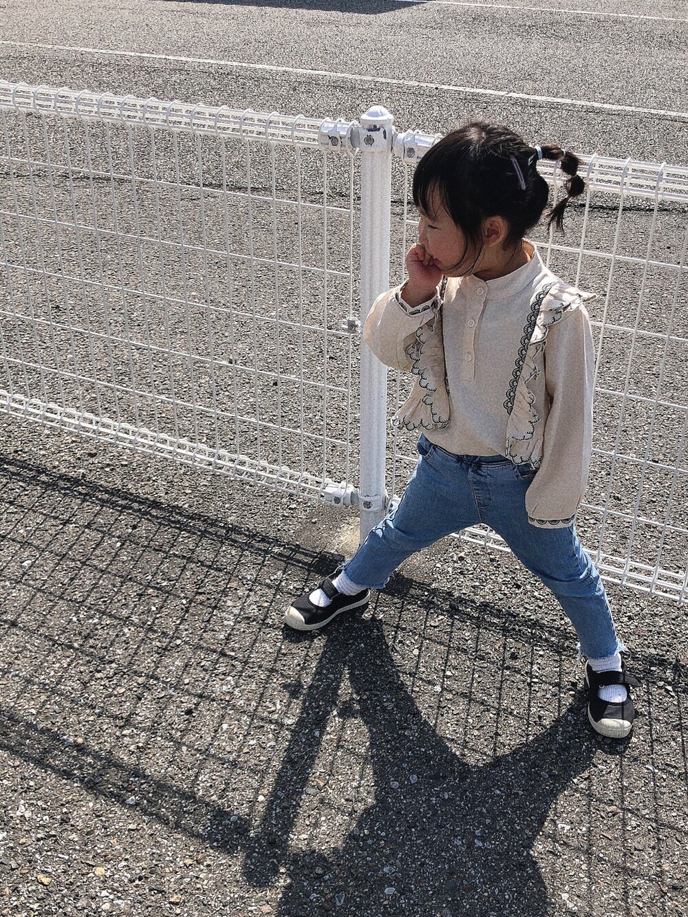 ブラック系のパンツ、ベージュ系のスニーカー、ホワイト系のパーカーを着用したキッズの冬コーディネートの3枚目の写真