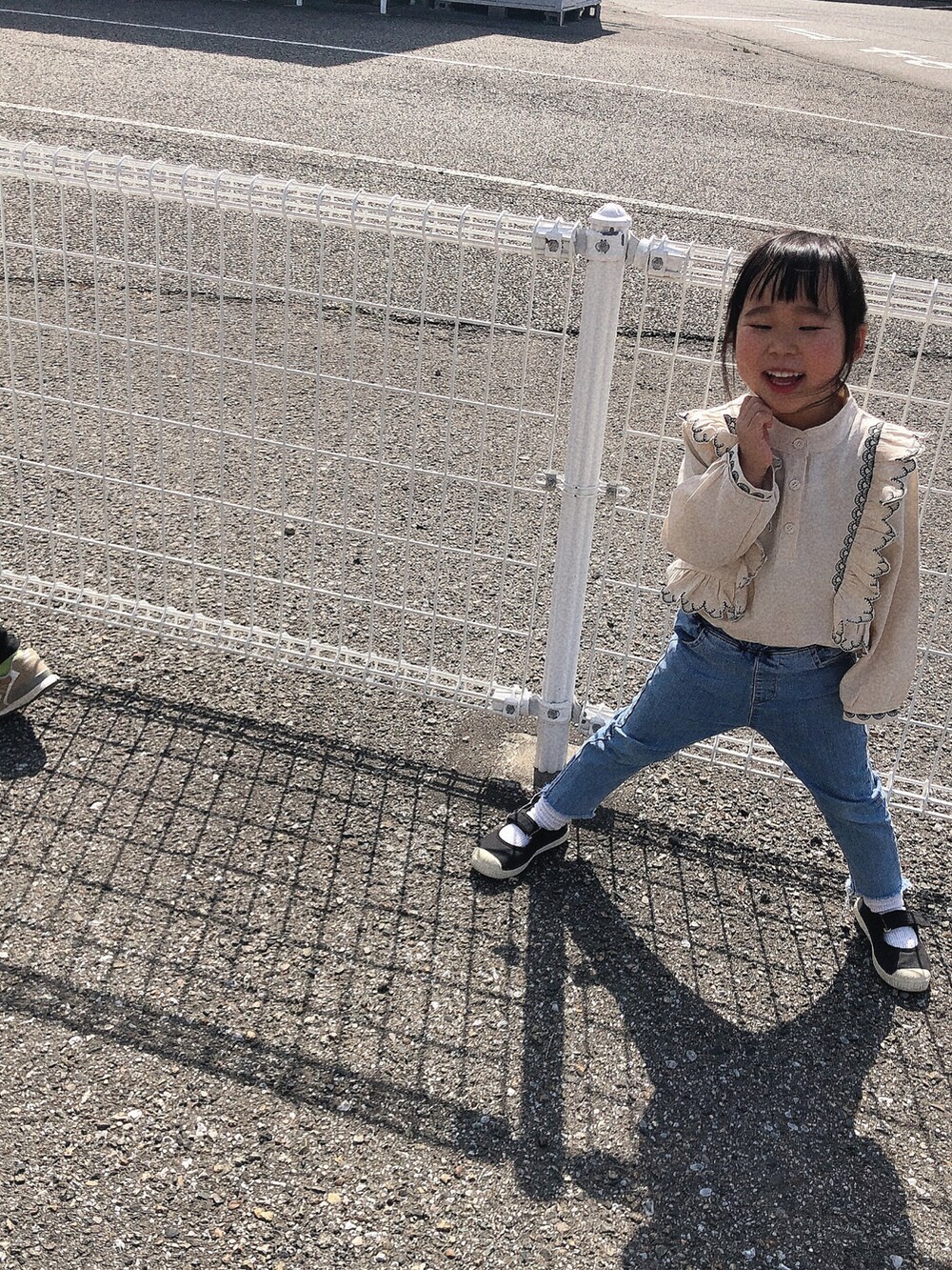 ブラック系のパンツ、ベージュ系のスニーカー、ホワイト系のパーカーを着用したキッズの冬コーディネートの2枚目の写真