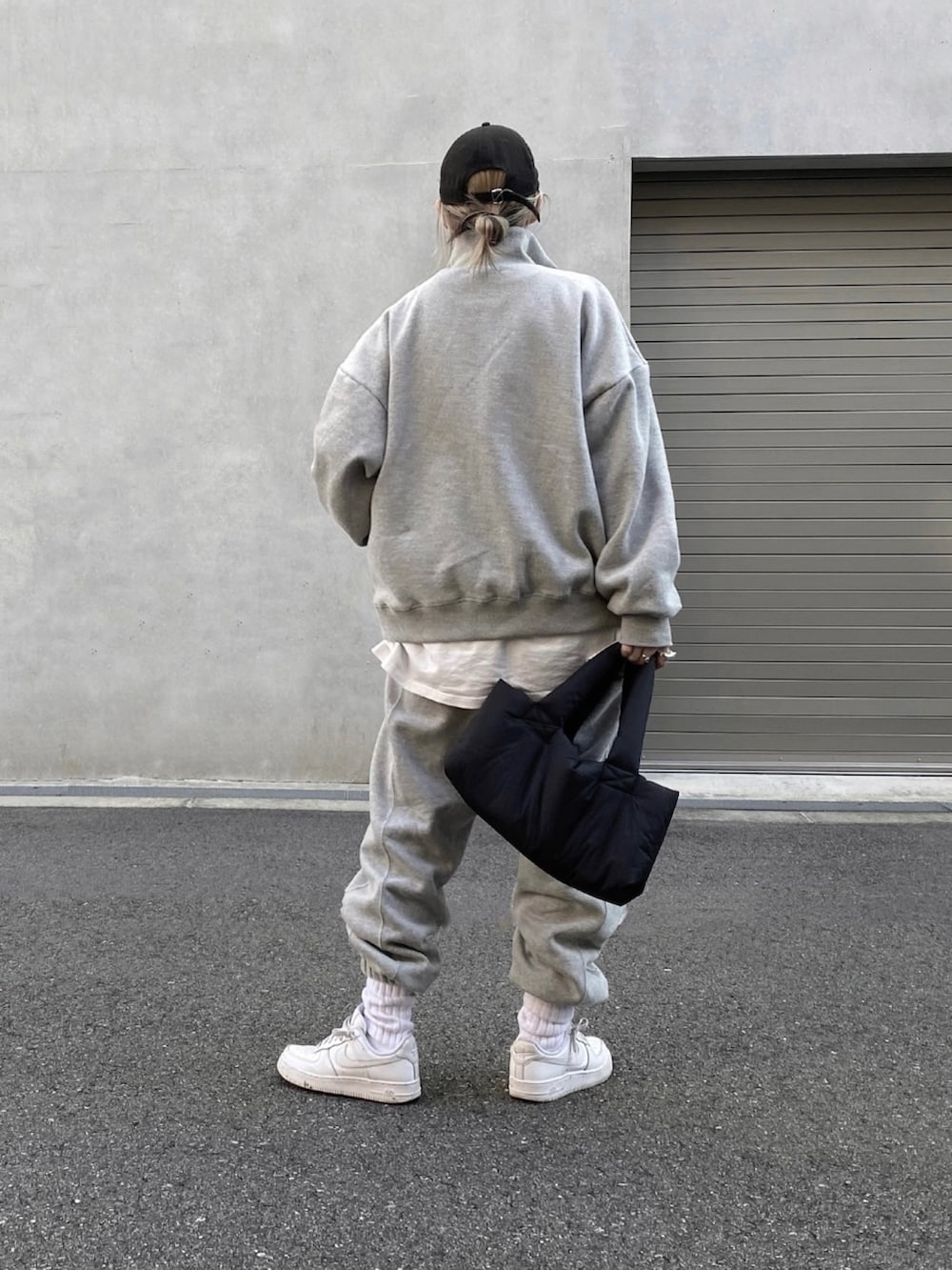 グレー系のスウェット、ホワイト系のTシャツ/カットソー、グレー系のスウェットパンツを着用したレディースの冬コーディネートの2枚目の写真