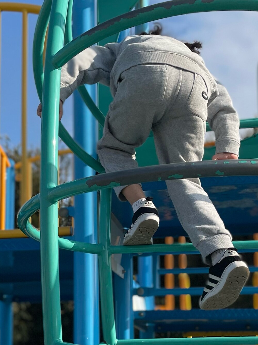 ブラウン系のバッグ、グレー系のトップス、グレー系のパンツを着用したキッズの春コーディネートの3枚目の写真