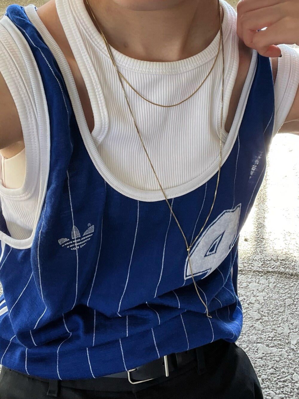 ブラック系のチノパンツ、ホワイト系のタンクトップ、ブラック系のショルダーバッグを着用したレディースの夏コーディネートの2枚目の写真